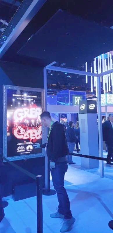 A visitor is immersed in sound under four ceiling-mounted AS-24i speakers at Intel's booth