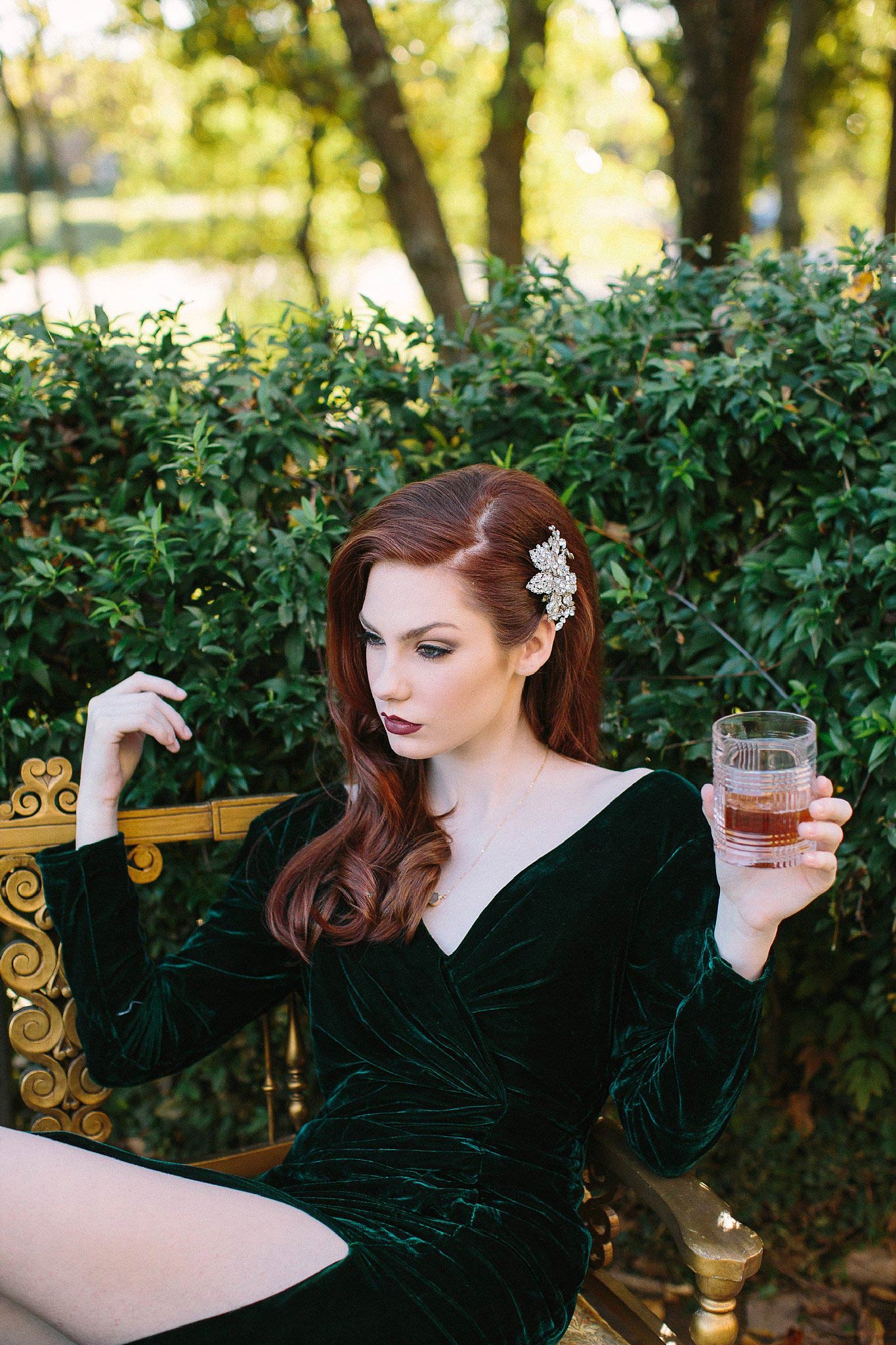 Redhead in velvet green dress drinking whiskey