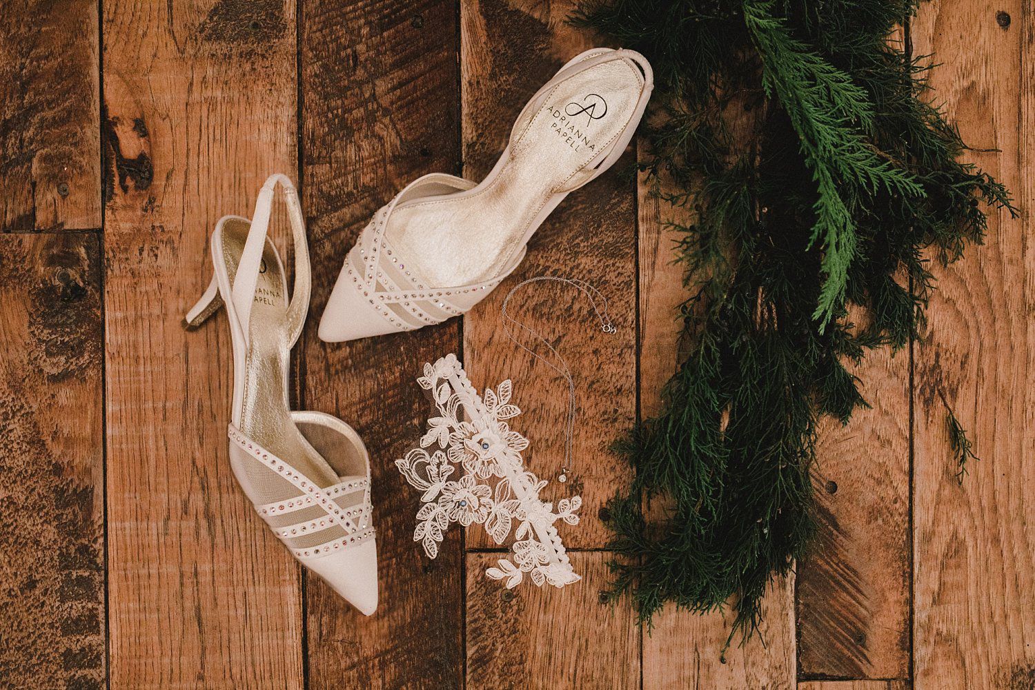 Hollow Hill Event Center Wedding bride;s shoes and garder with evergreen greenery