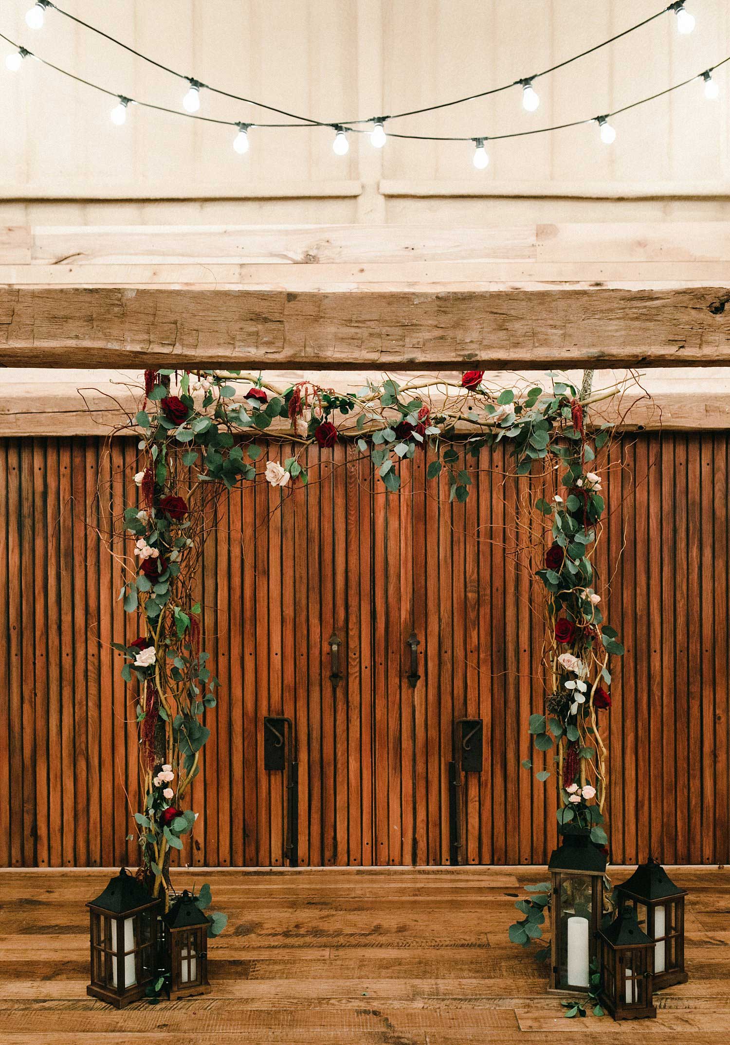 Hollow Hill Farm Event Center Wedding ceremony archway with wooden lanterns