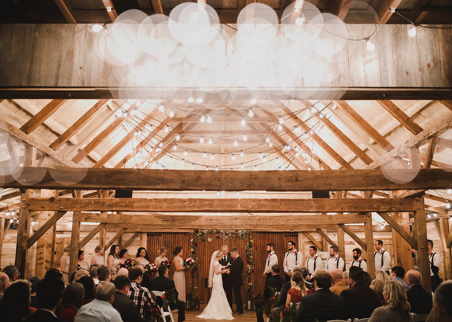 Hollow Hill Farm Event Center Wedding ceremony in wooden barn with cafe lights