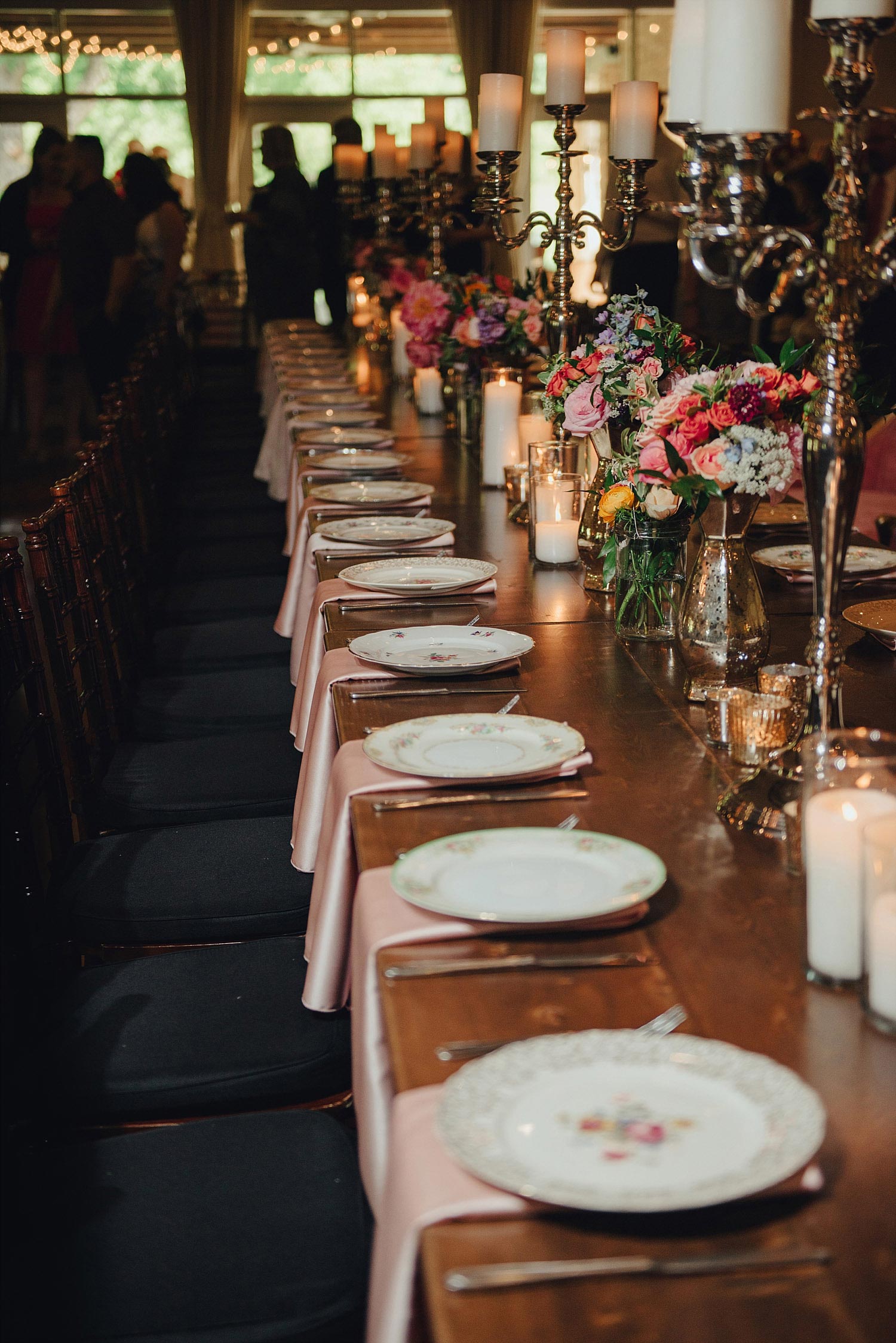 The Orchard Azle wedding wood farm table with vintage plates and candelabras