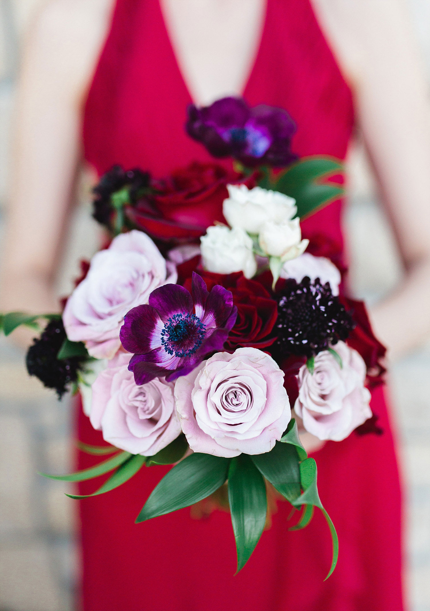 Castle at Rockwall wedding bridesmaid in red dress holding blush red and marsala bouquet