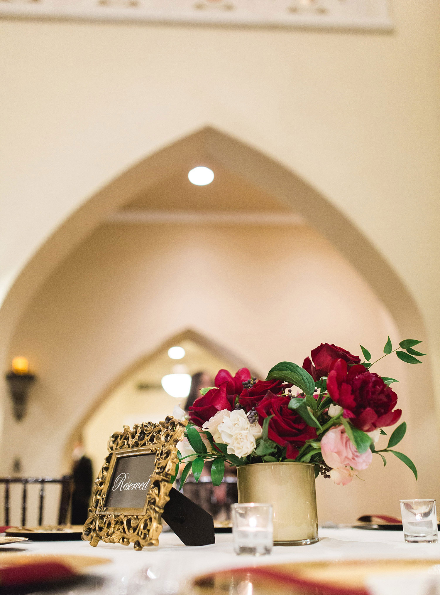 Castle at Rockwall wedding red flowers in gold vase with gold table number