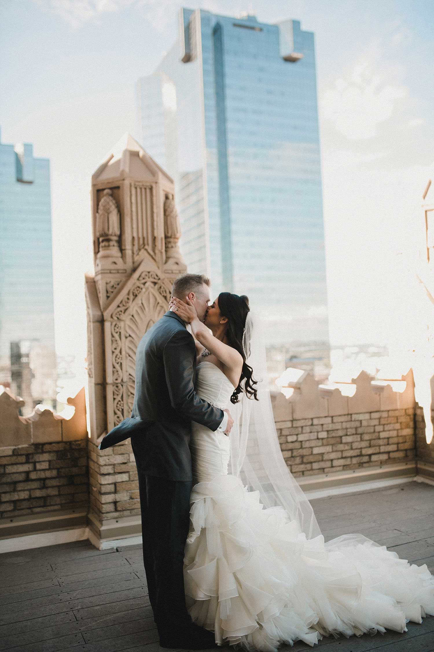 Bride and Groom kissing on the Worthington Hotel rooftop