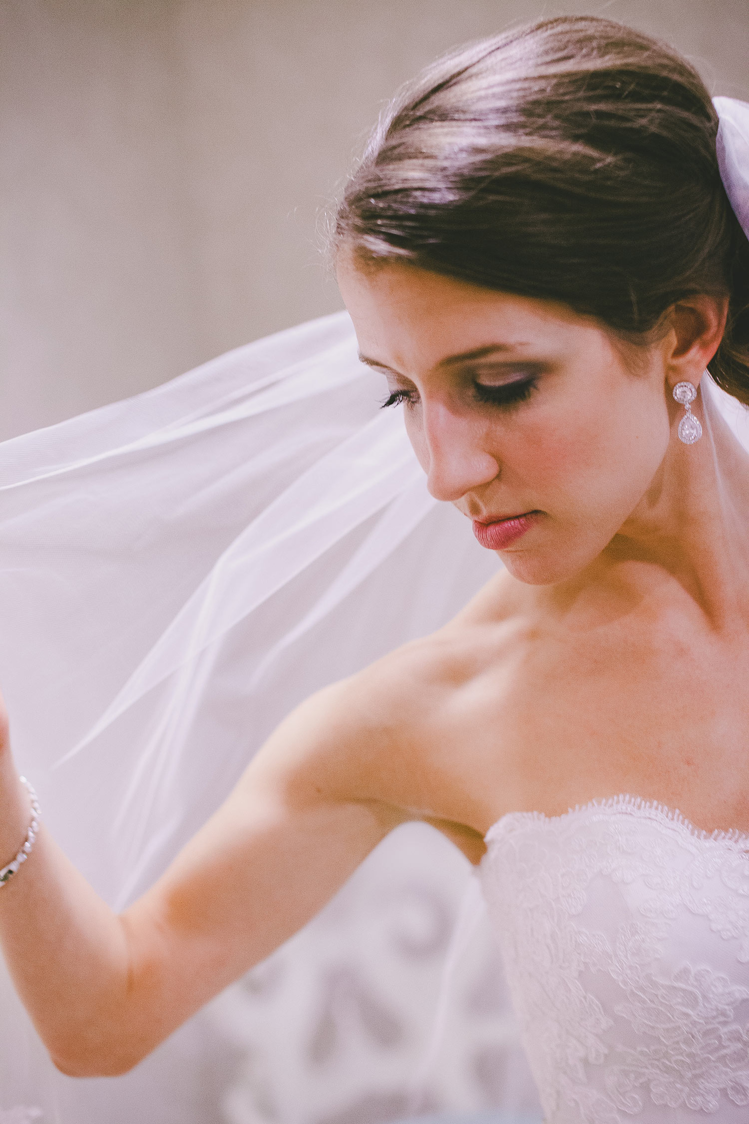 Bride with brown hair holding veil