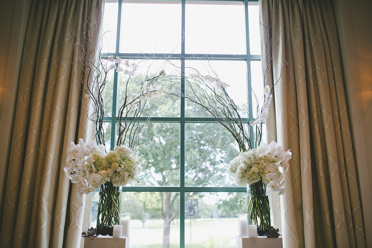 River Crest Country Clube Ceremony archway with white flowers, orchids, willow branches,  and white platforms