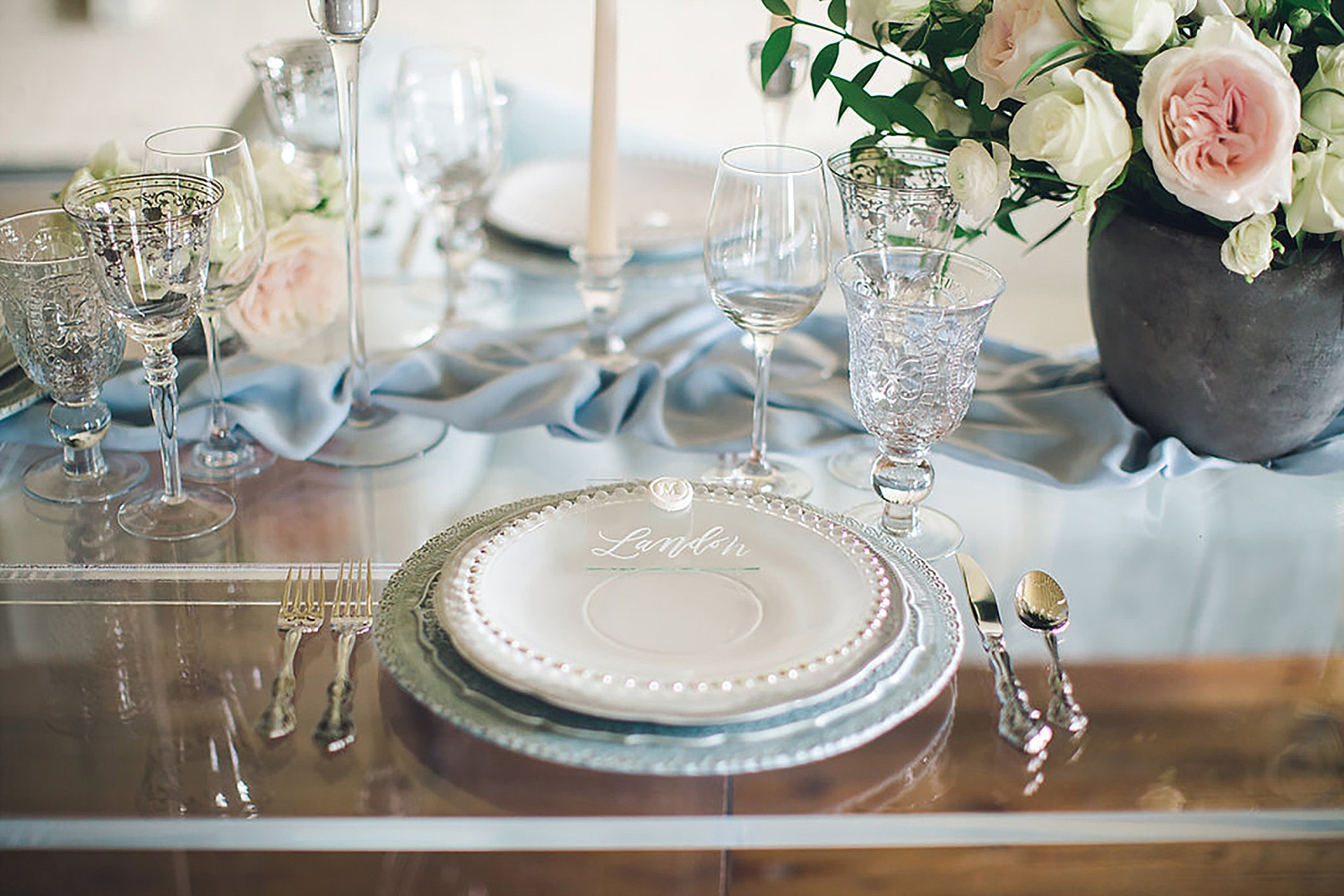 Dusty blue place setting with a acrylic place card with a white wax seal