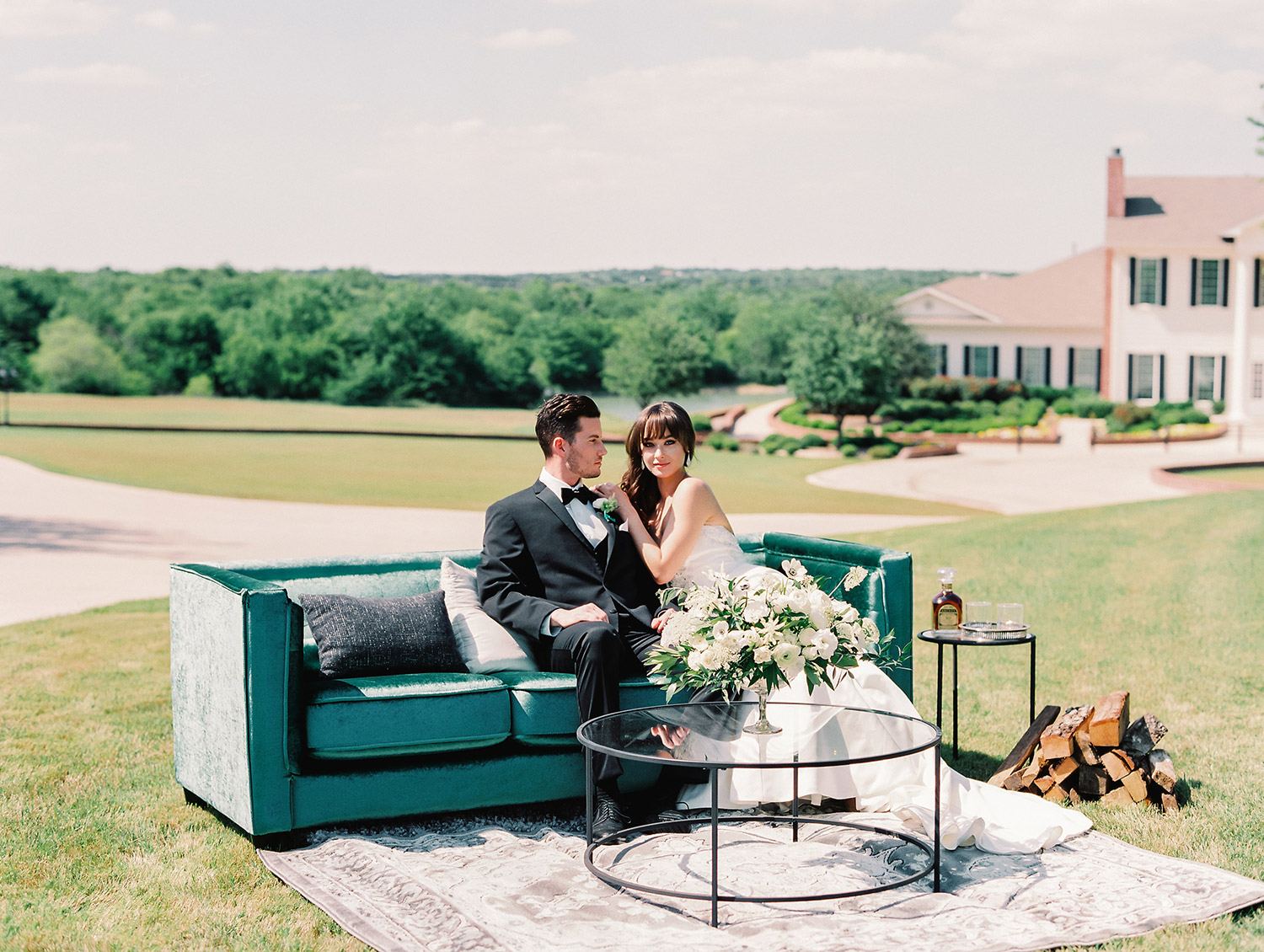 Bride and groom sitting on a emerald sofa at a wedding lounge