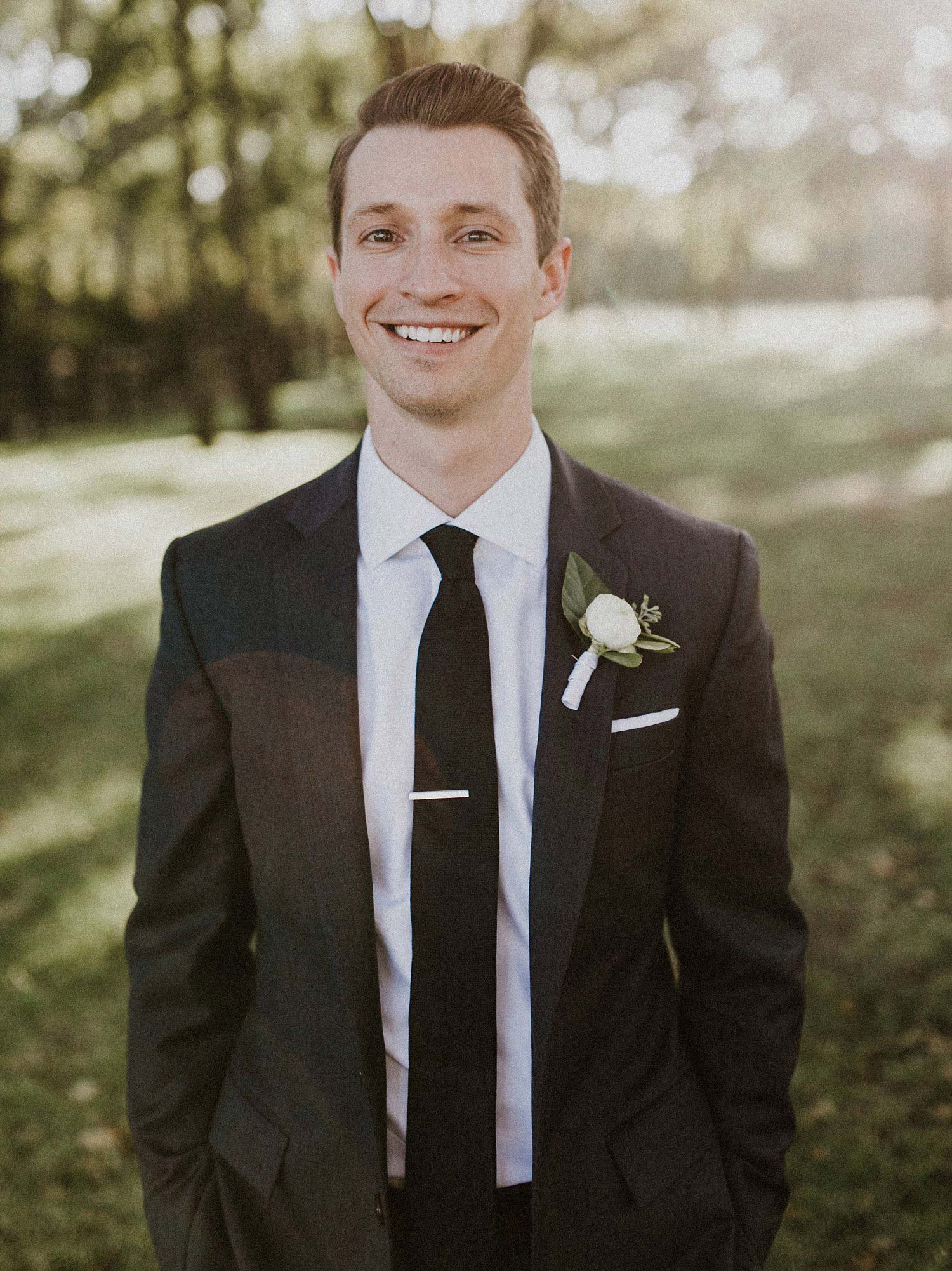 We love this classic groom's attire for this barn wedding.  He wore a dark grey suite, black tie, and white boutonniere