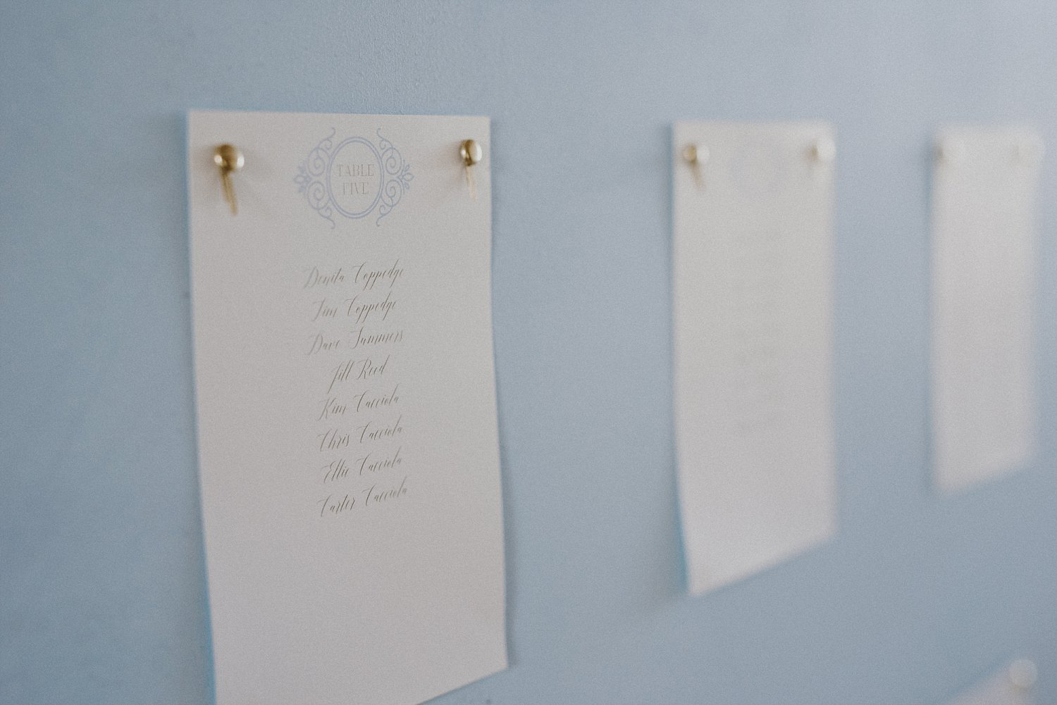 Guest place cards on dusty blue board for White Sparrow Barn wedding