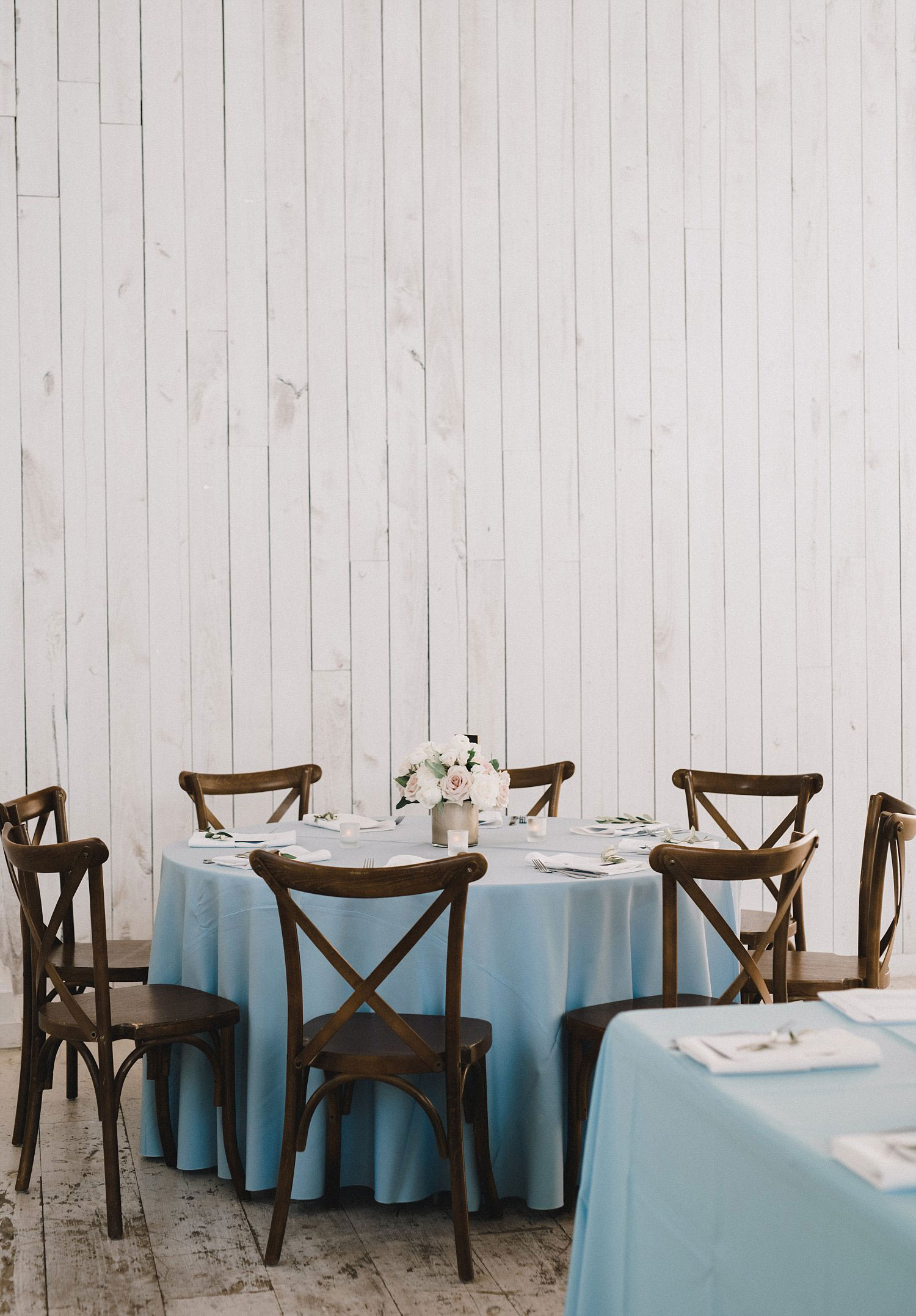 White Sparrow Barn wedding dusty blue linen on round table with cross back chairs