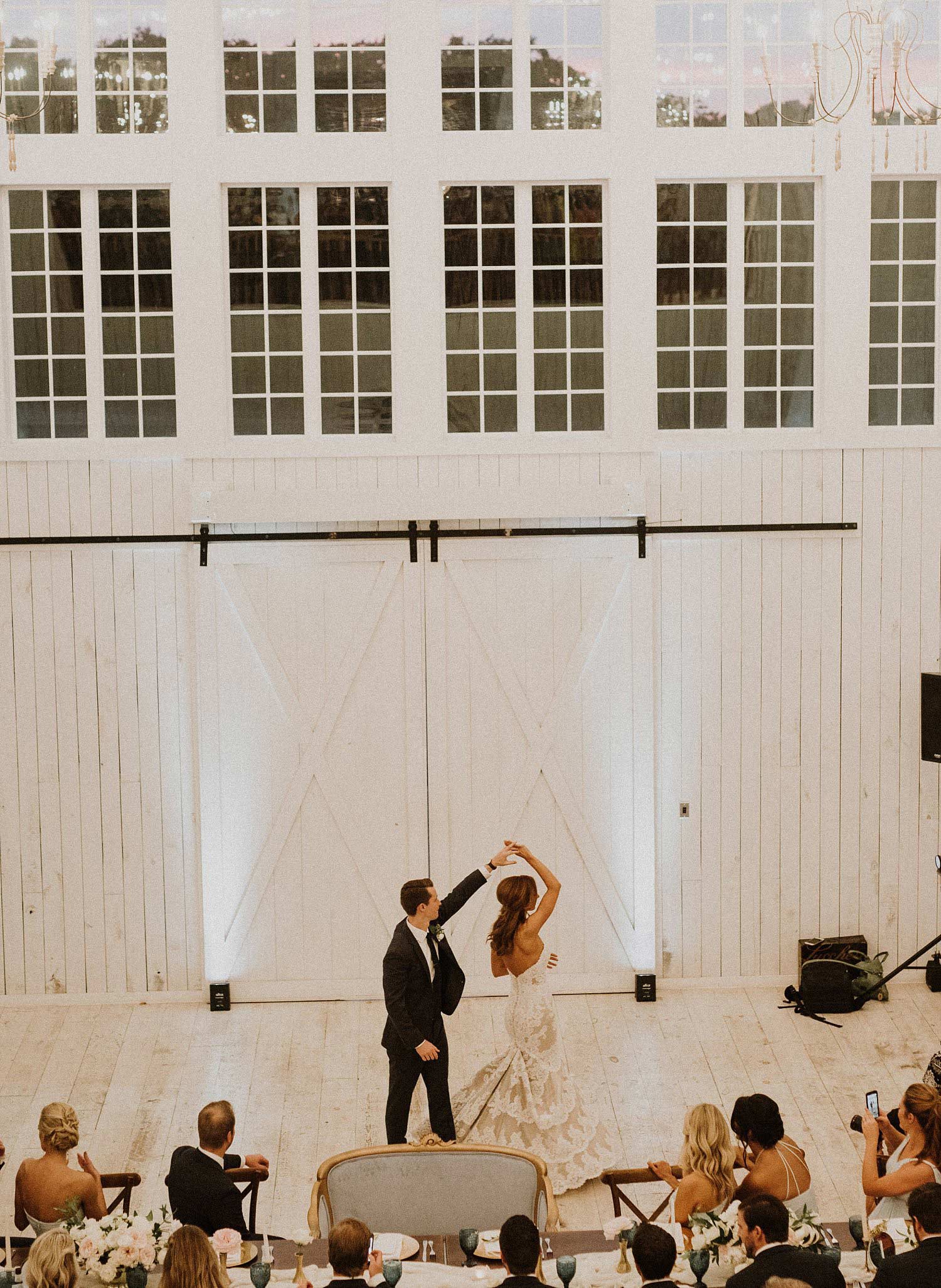 Bride and groom first dance at White Sparrow Barn with white upighting