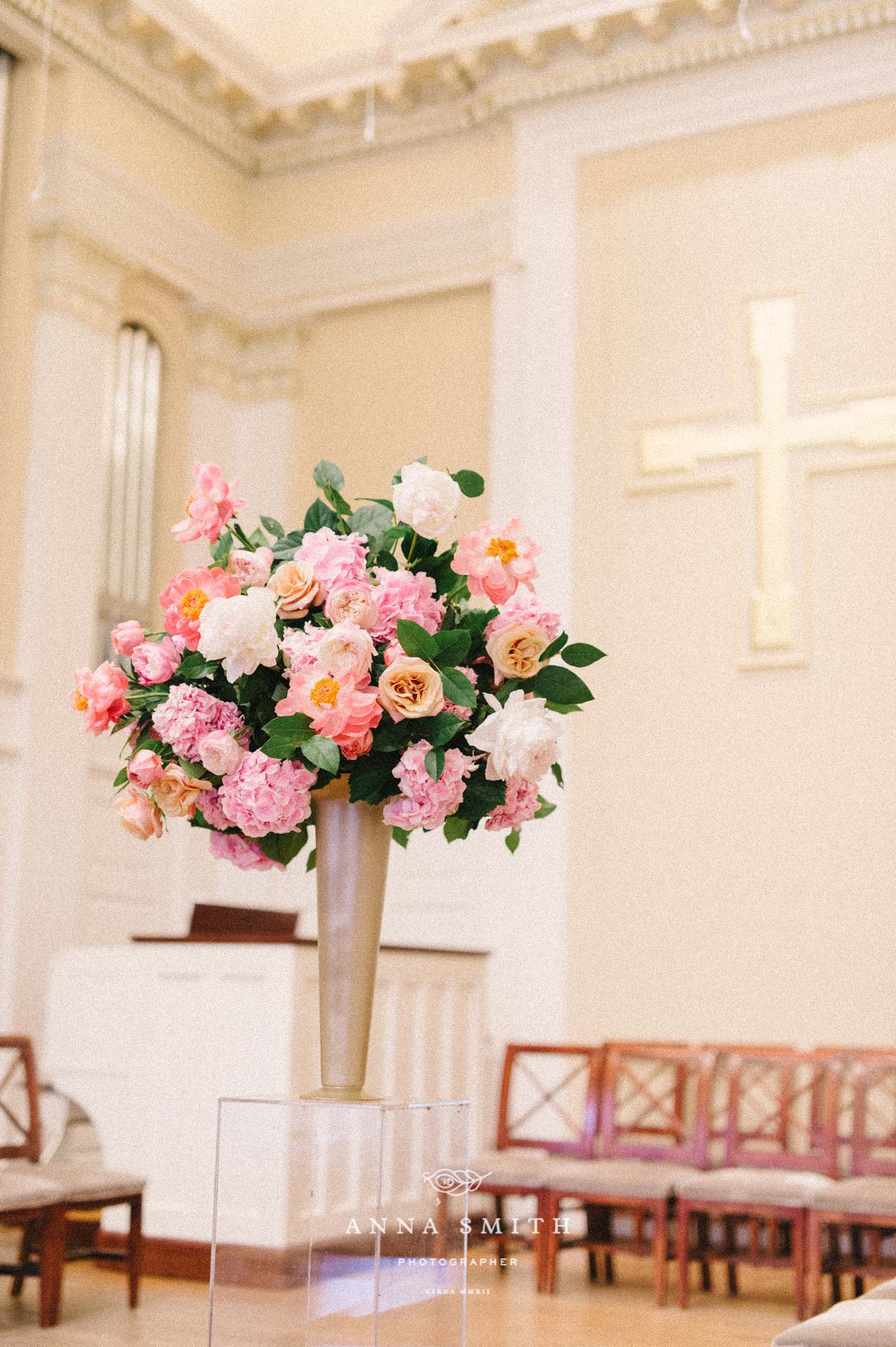 Tall pink garden style arrangement in church ceremony