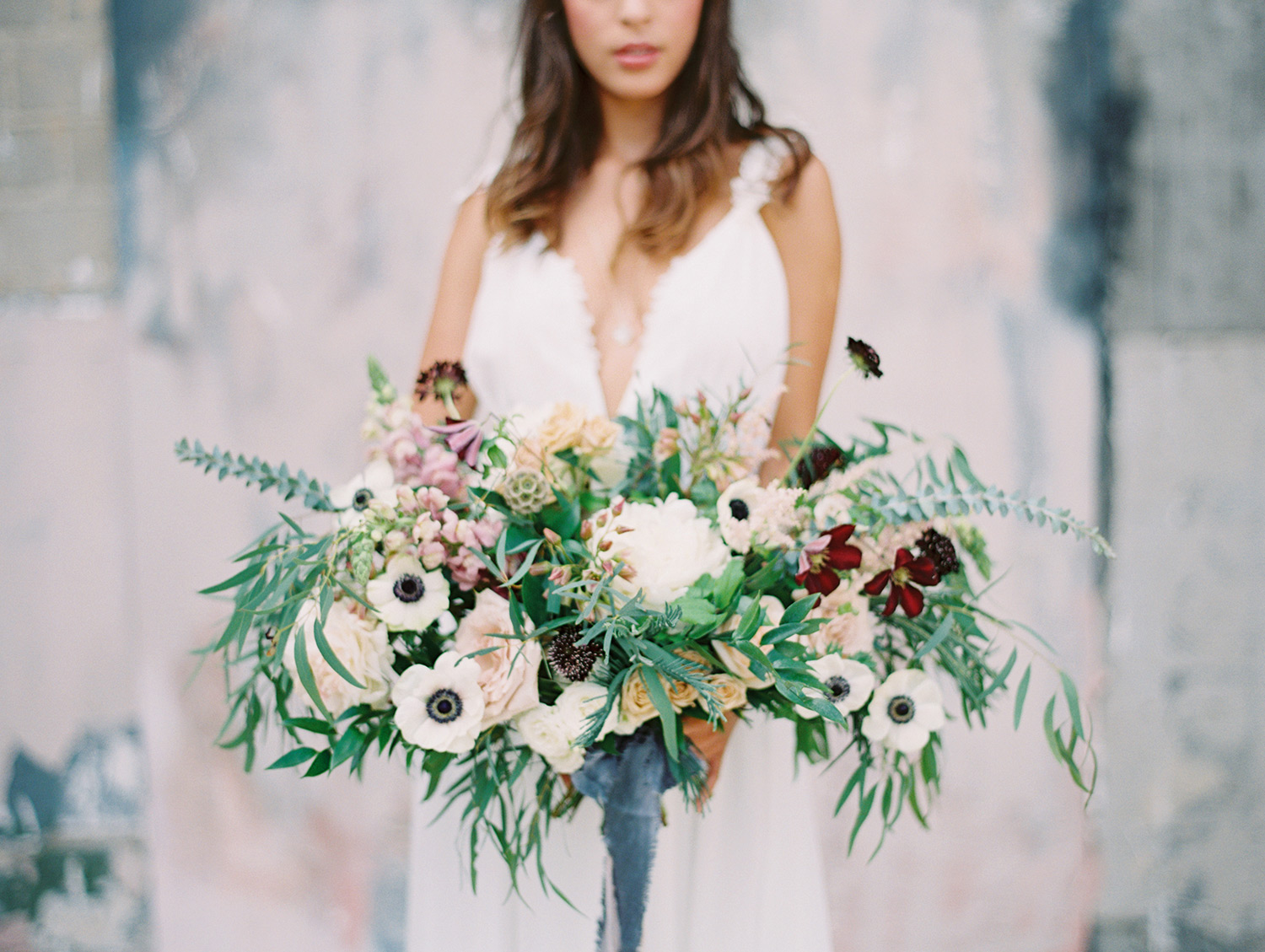 Bride holding a blue white green purple bouquet