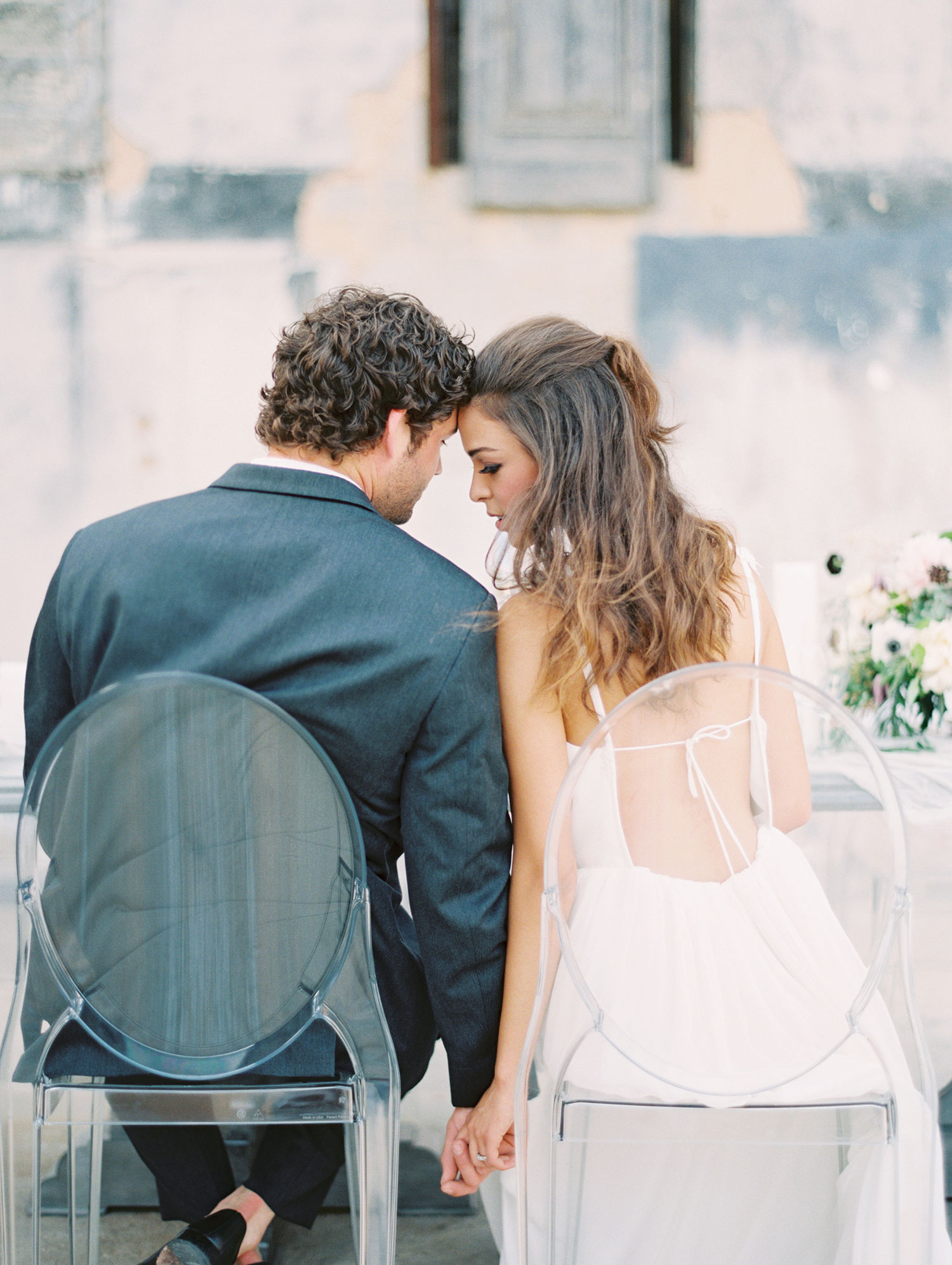 romantic bride and groom sitting at ghost chairs