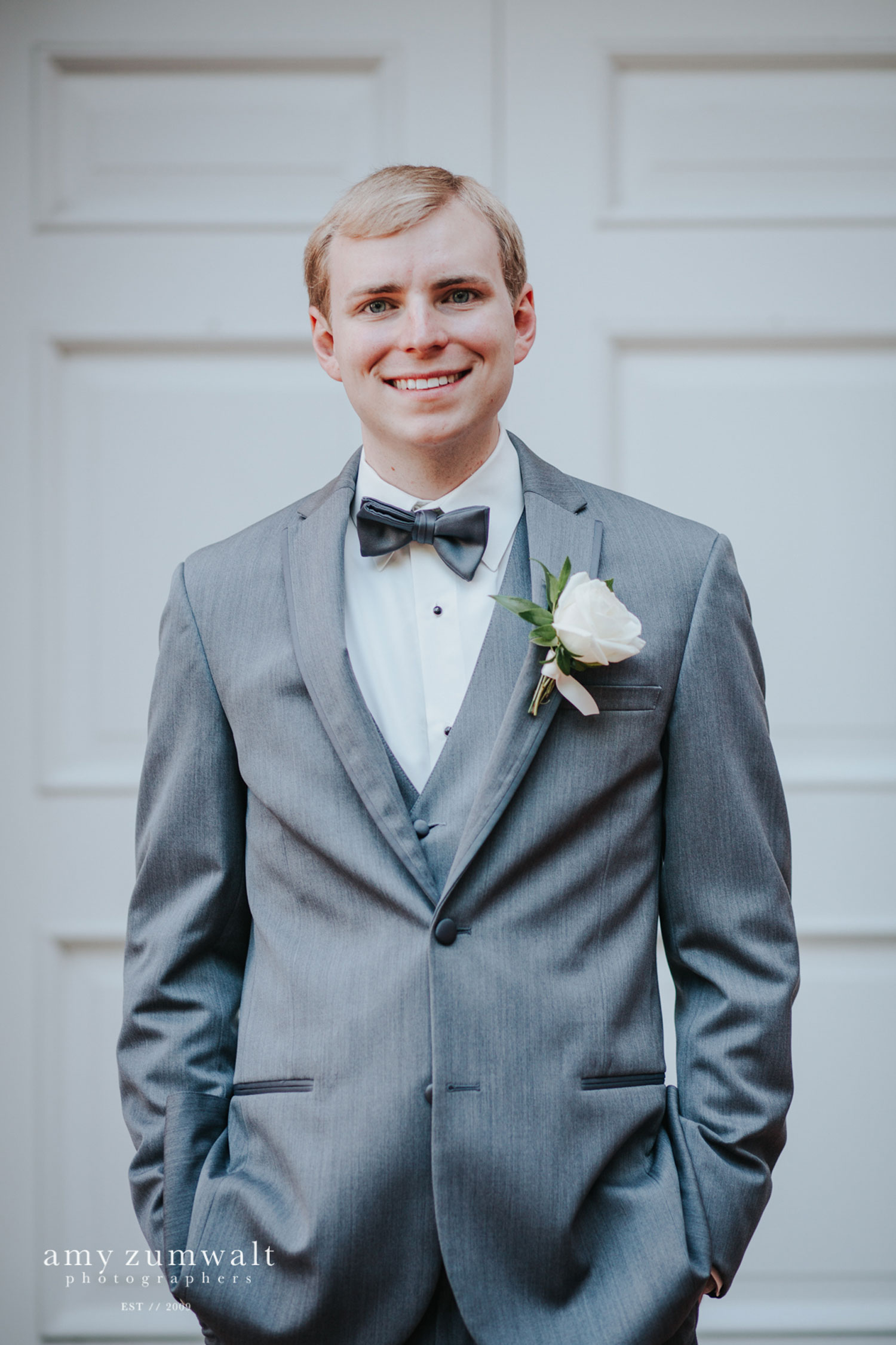 Groom in a grey suite with a blue bowtie