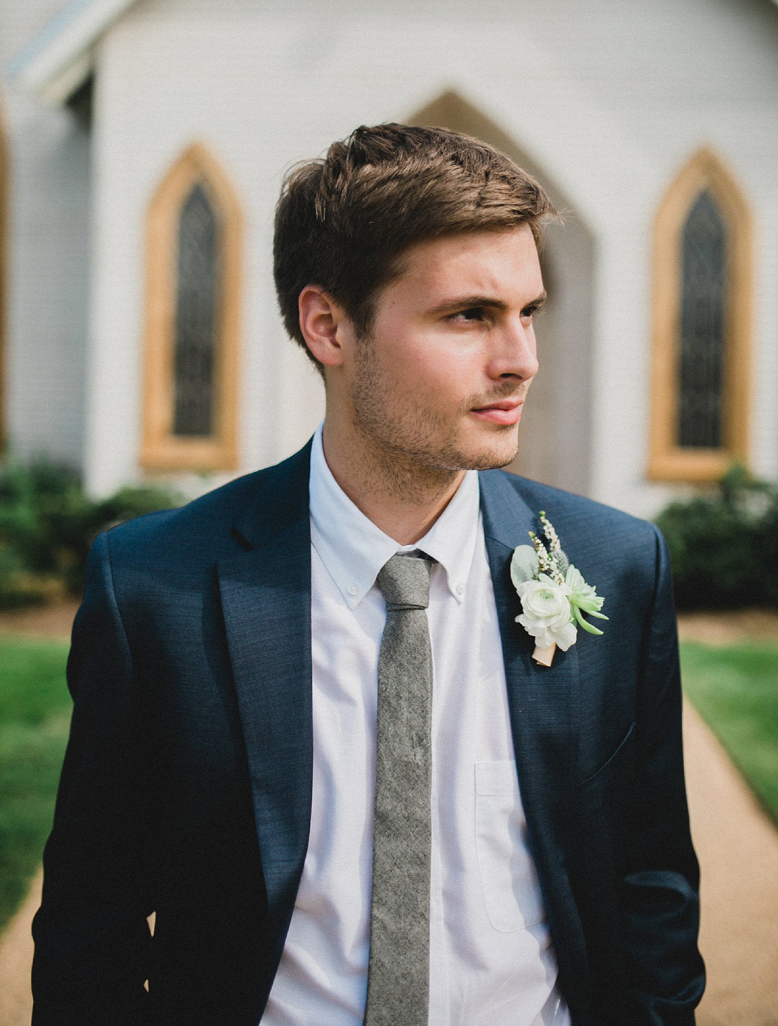 Groom in navy suite with succulent boutonniere