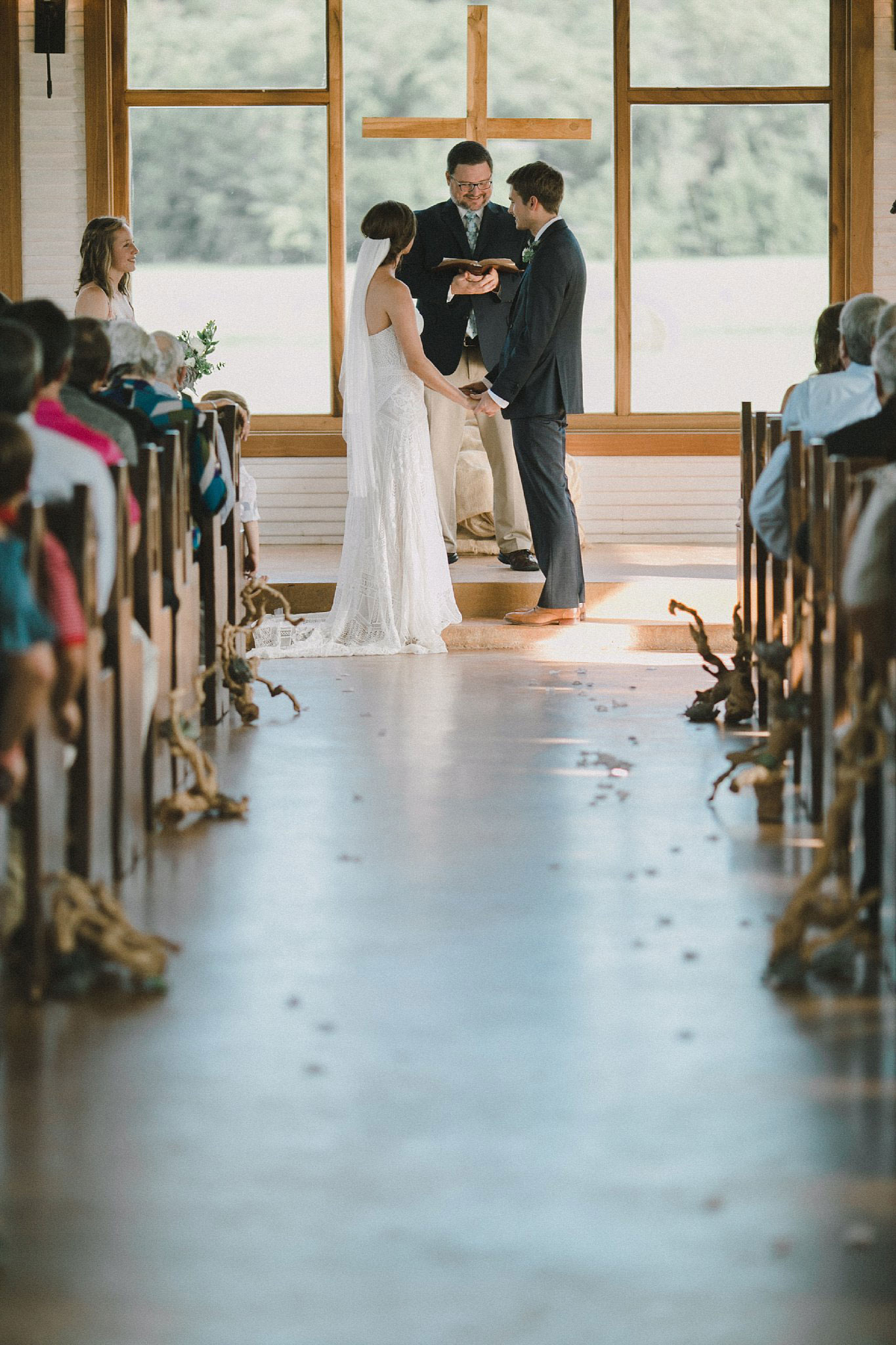 Brooks at Weatherford wedding ceremony with driftwood lining the wedding aisle