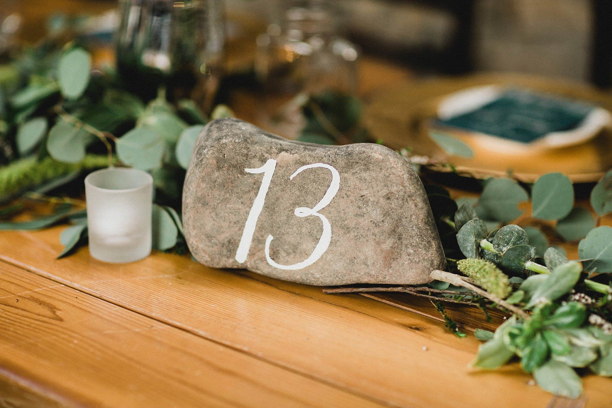 Rock table number with white calligraphy for organic mountain wedding