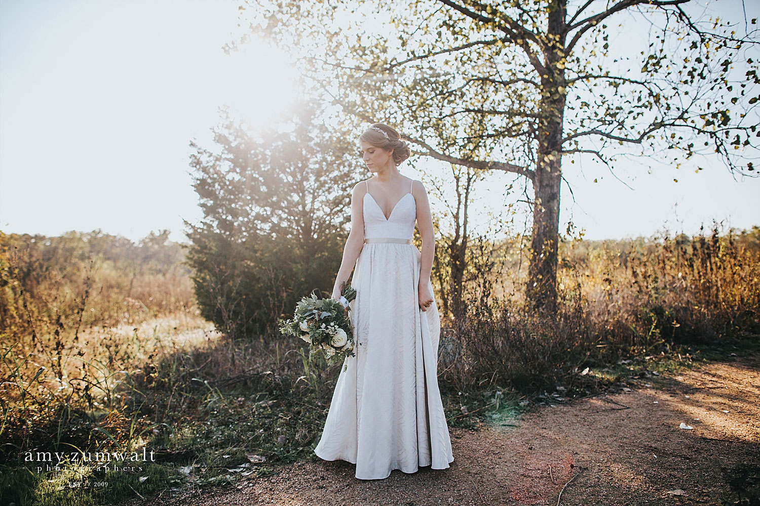 Bride holding a greenery bouquet in woodland scenery