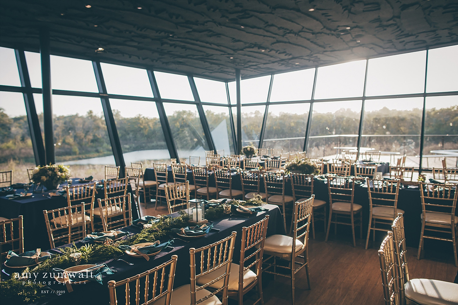 Trinity River Audubon Center wedding reception with gold chairs and navy linens