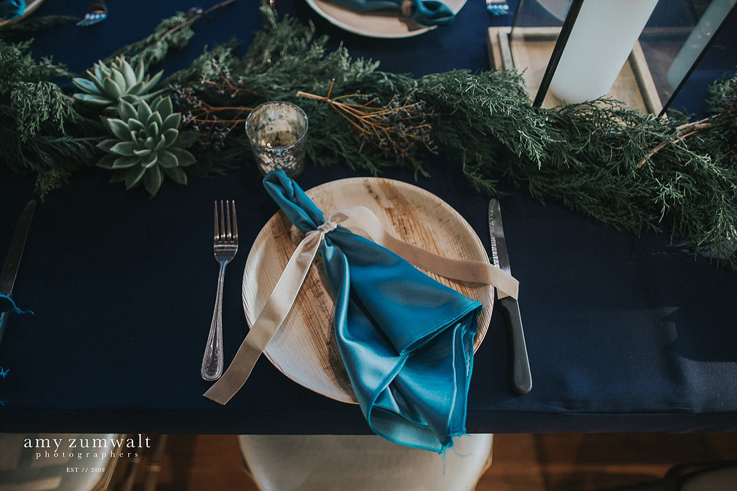 Wood plate with a light blue napkin tied with velvet ribbon