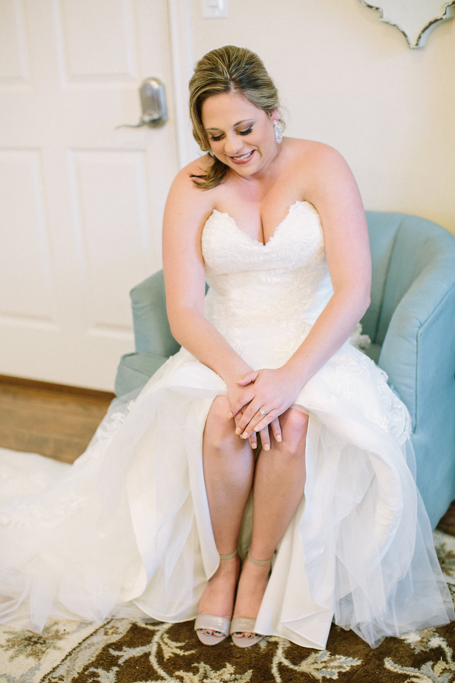 Bride sitting in blue chair at the Orchard in Azle bridal suite