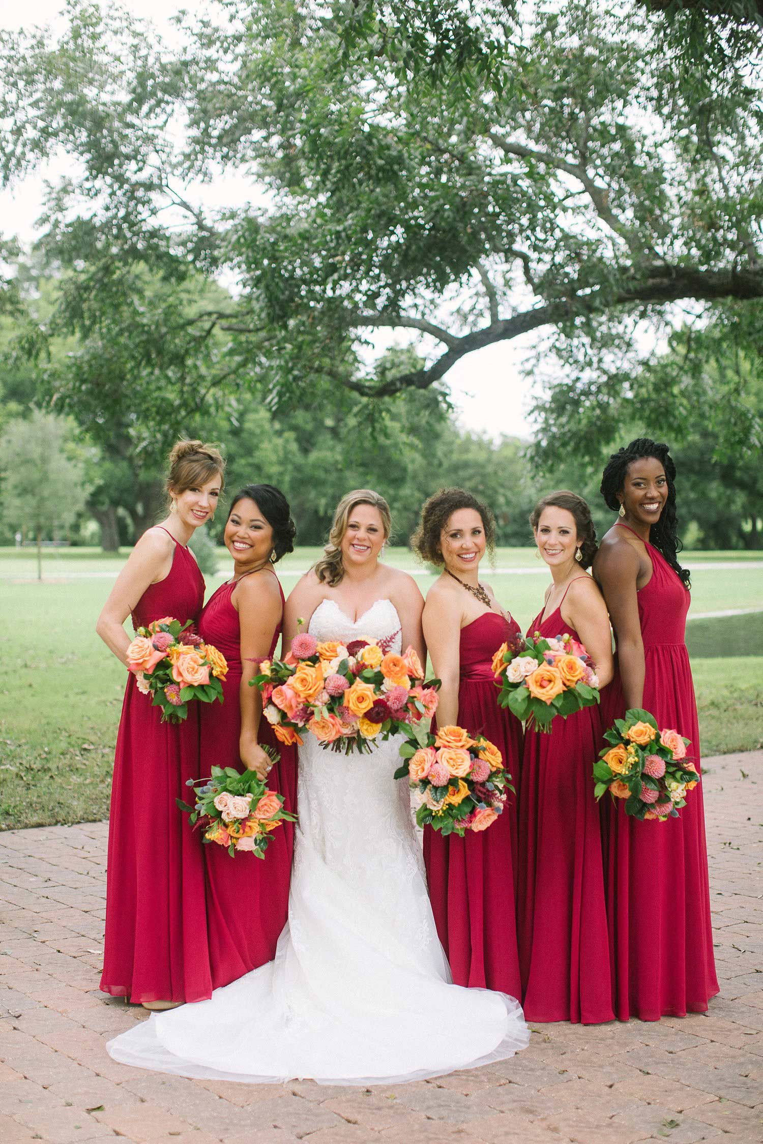 Bridesmaids with burgundy dresses and colorful flowers at the Orchard in Azle