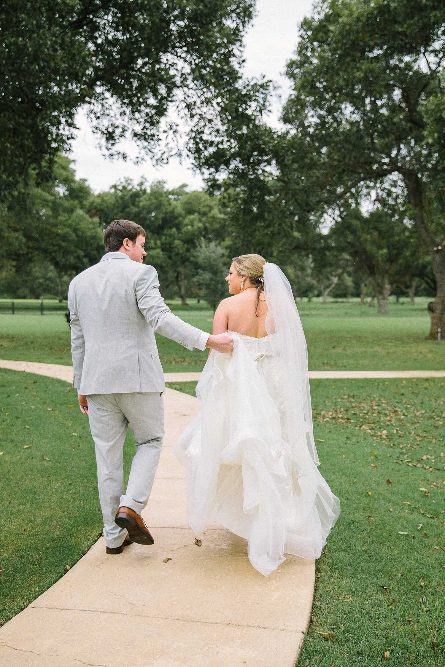 Bride and groom walking away from the ceremony at the Orchard in Azle TX