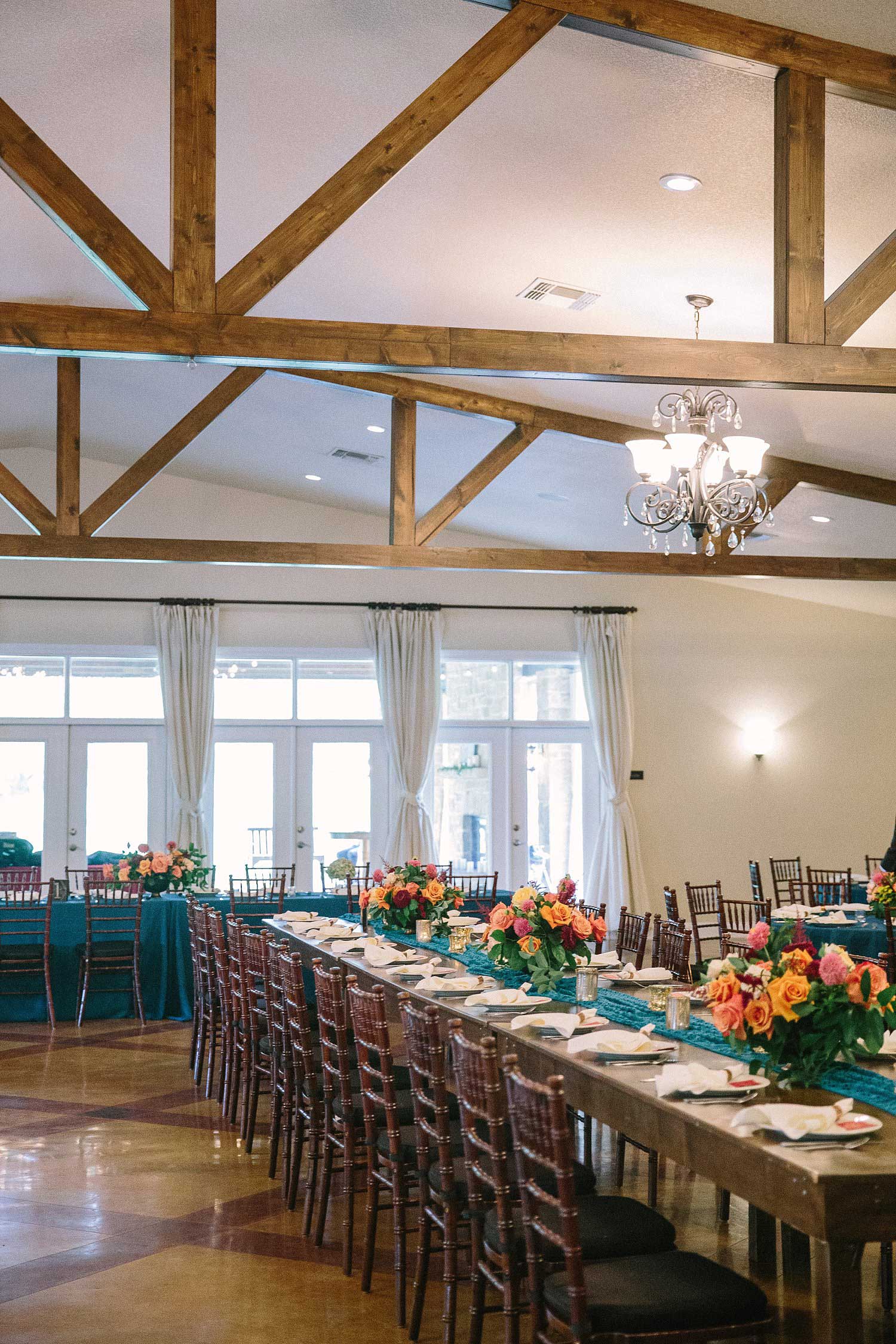 The orchard Azle TX wedding reception with blue tablecloths and a farm table