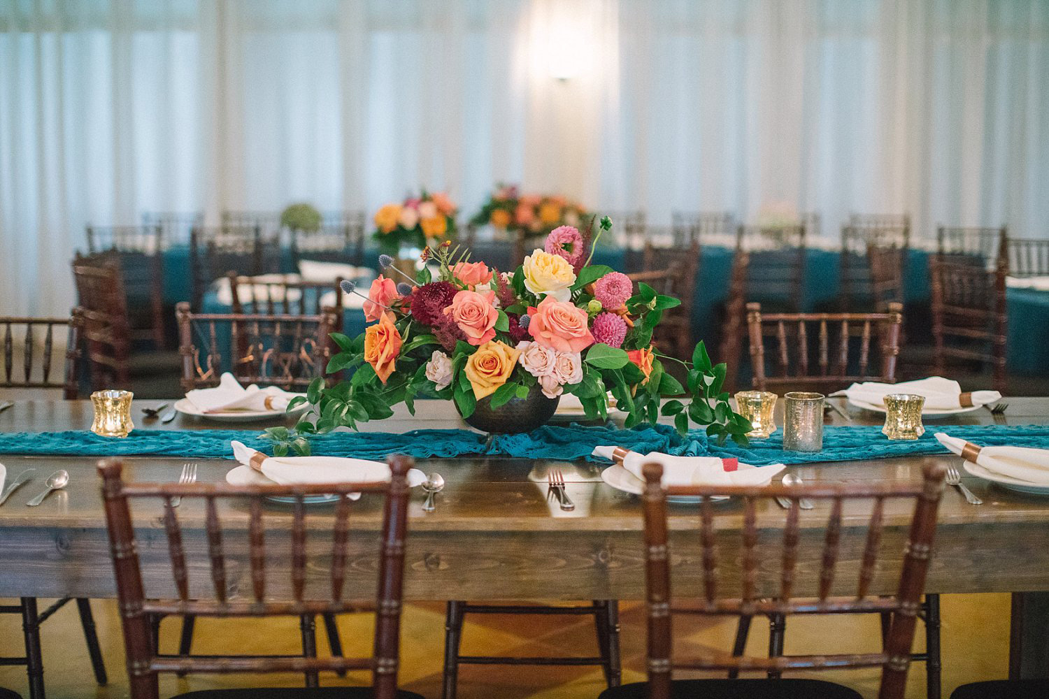 Farm table with a teal runner and colorful fall flowers