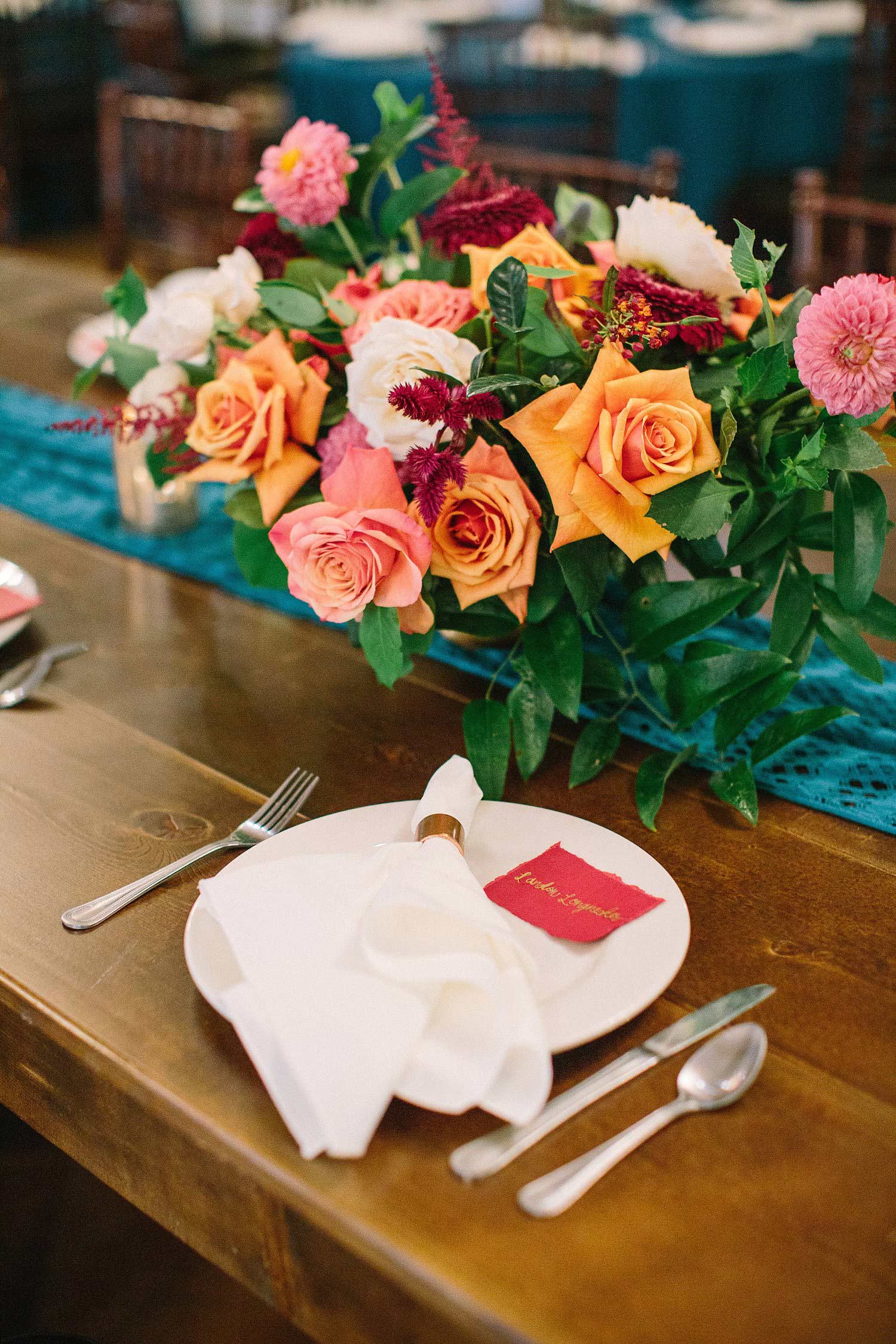 Napkin with copper napkin ring on white plate with a red escort card