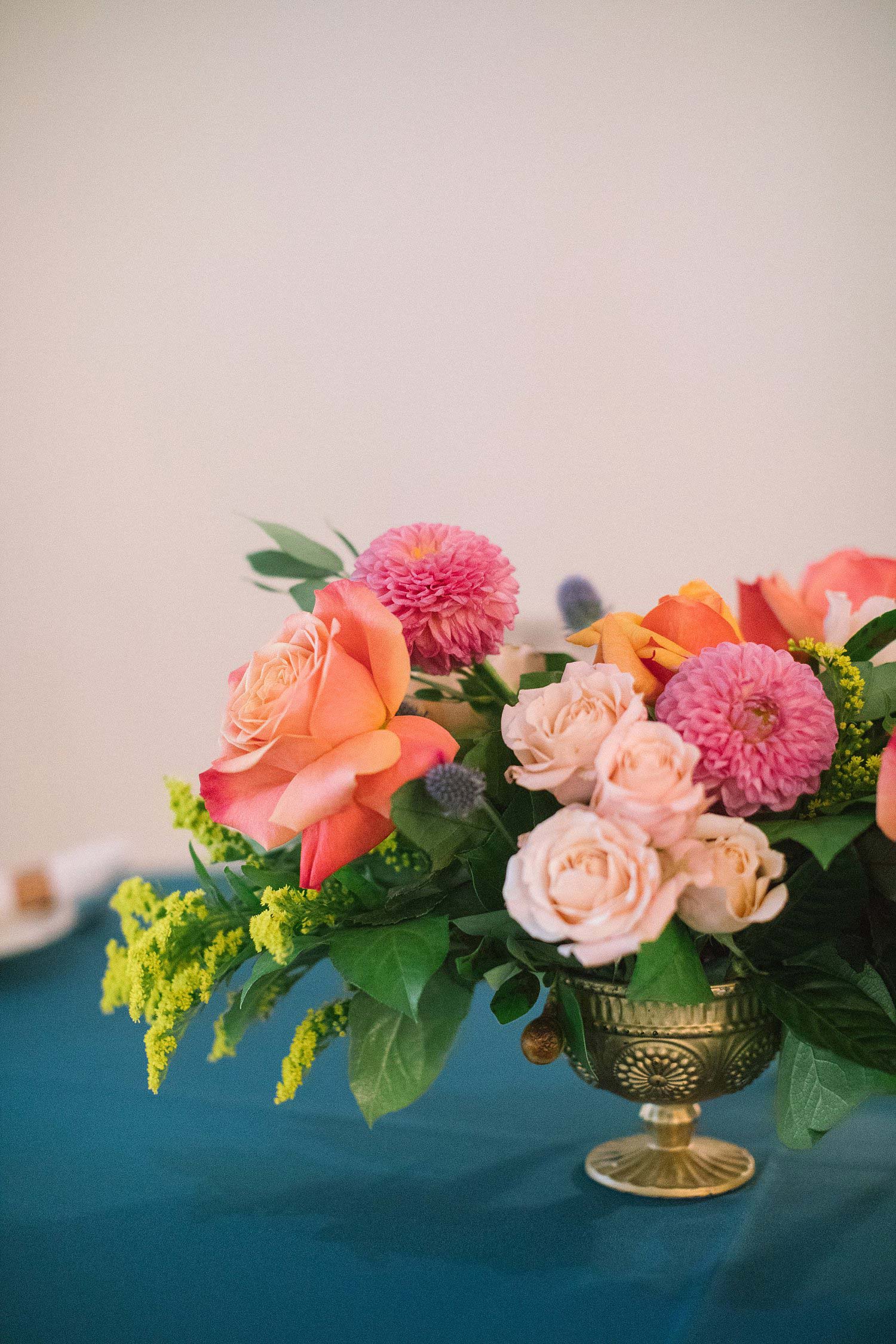 coral cream and apricot flowers with a blue tablecloth
