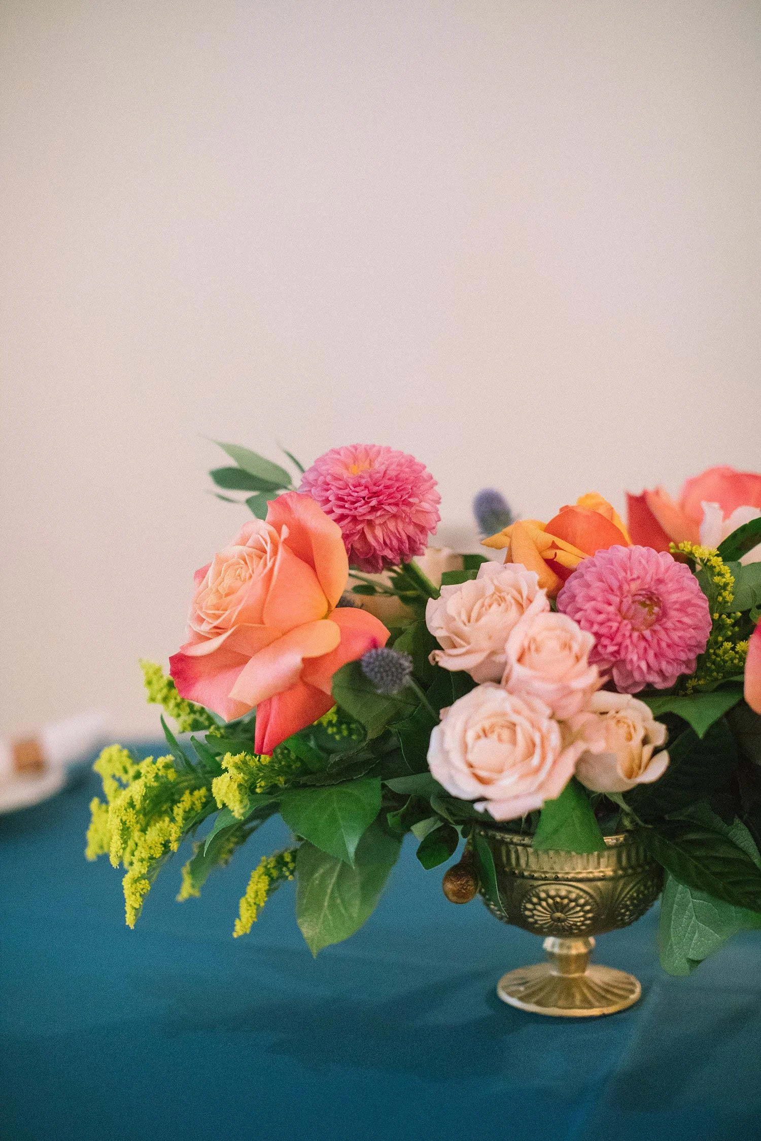 coral cream and apricot flowers with a blue tablecloth