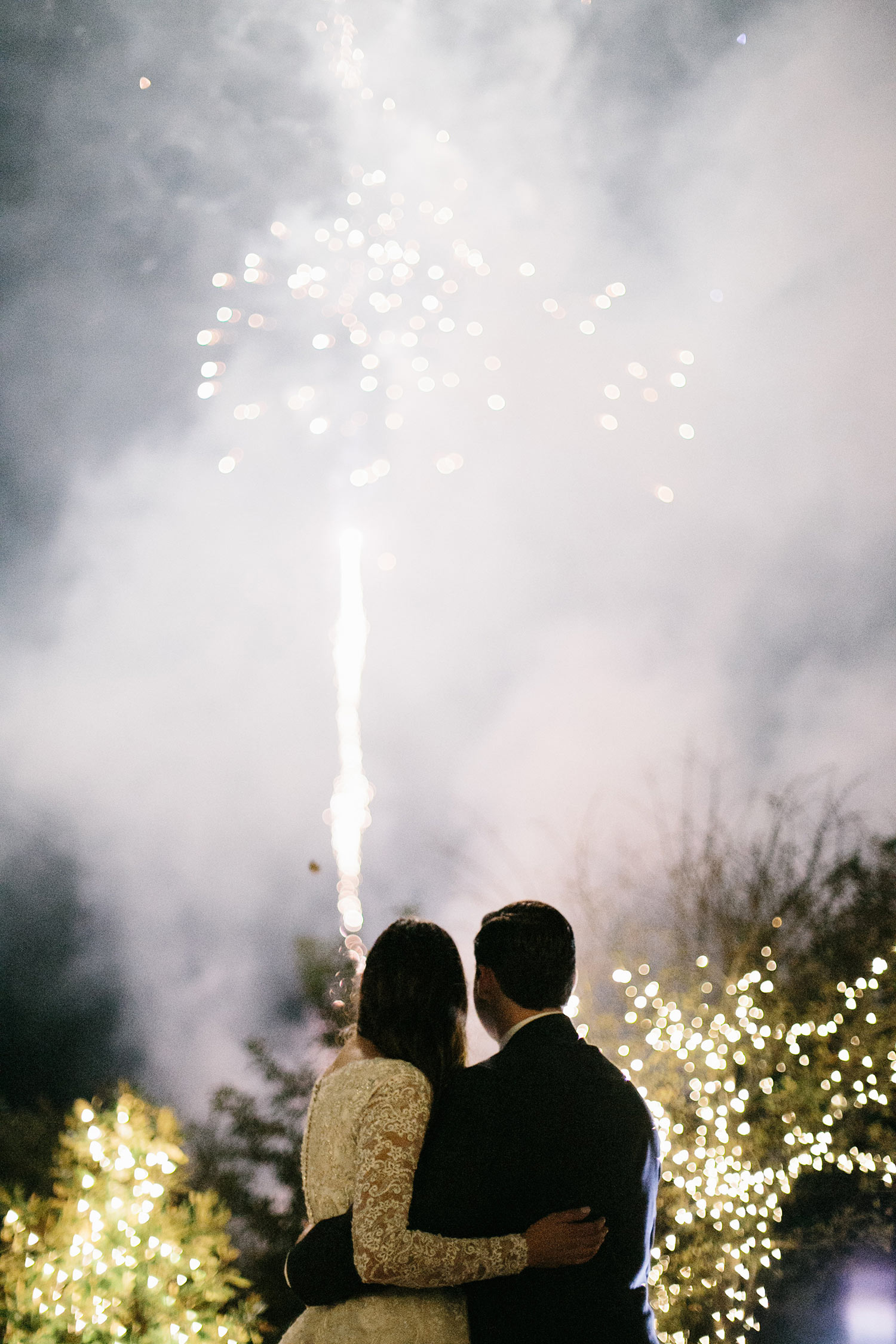 Bride and groom watching fireworks at the end of the reception