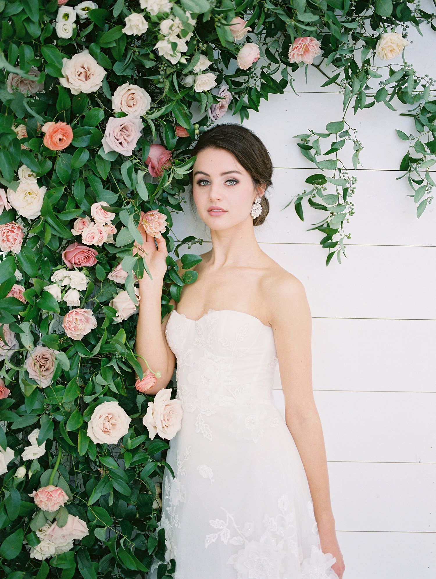 Bride standing next to a rose bush
