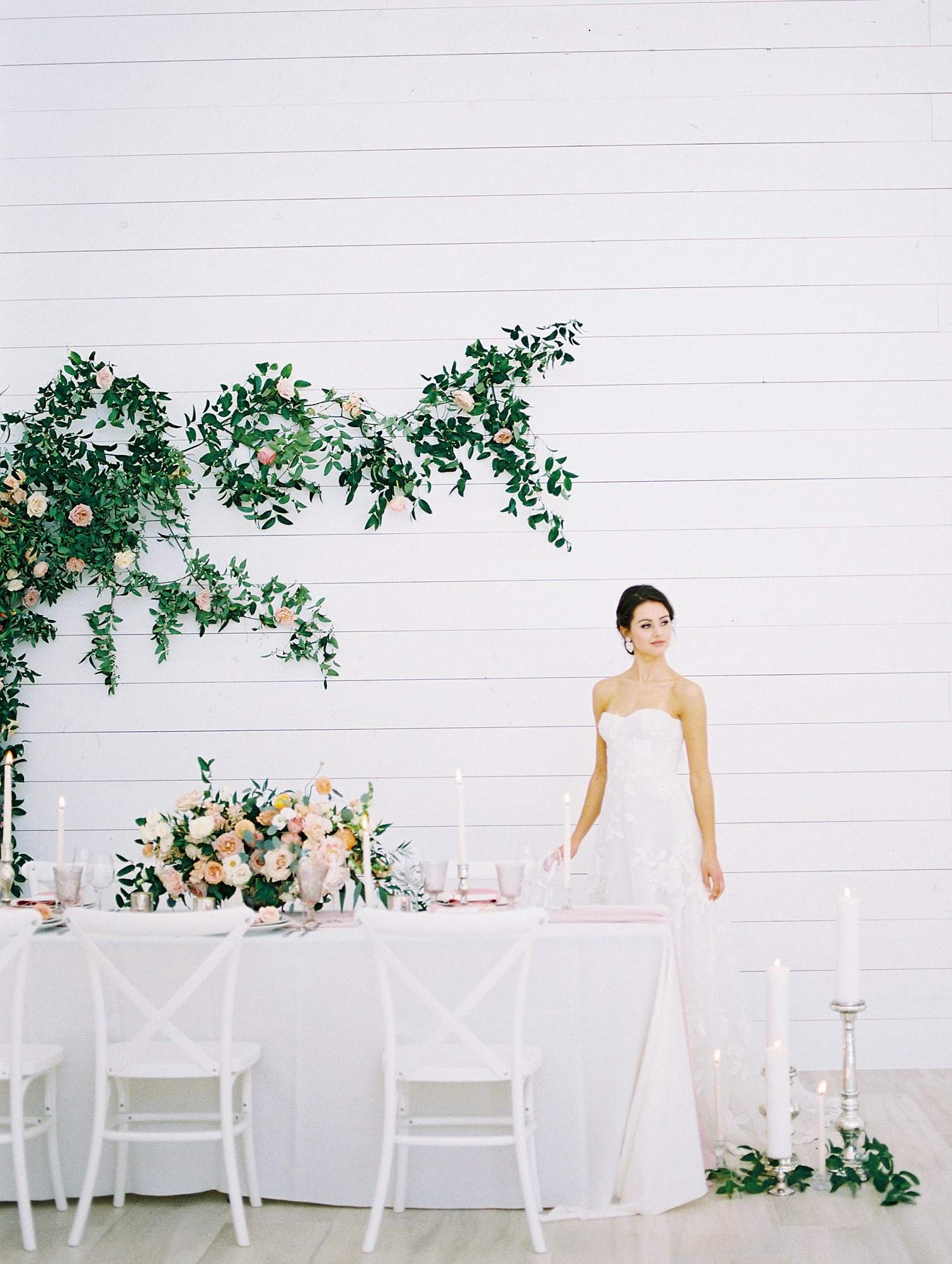 White tablescape and greenery wall feature at the Nest at Ruth Farms