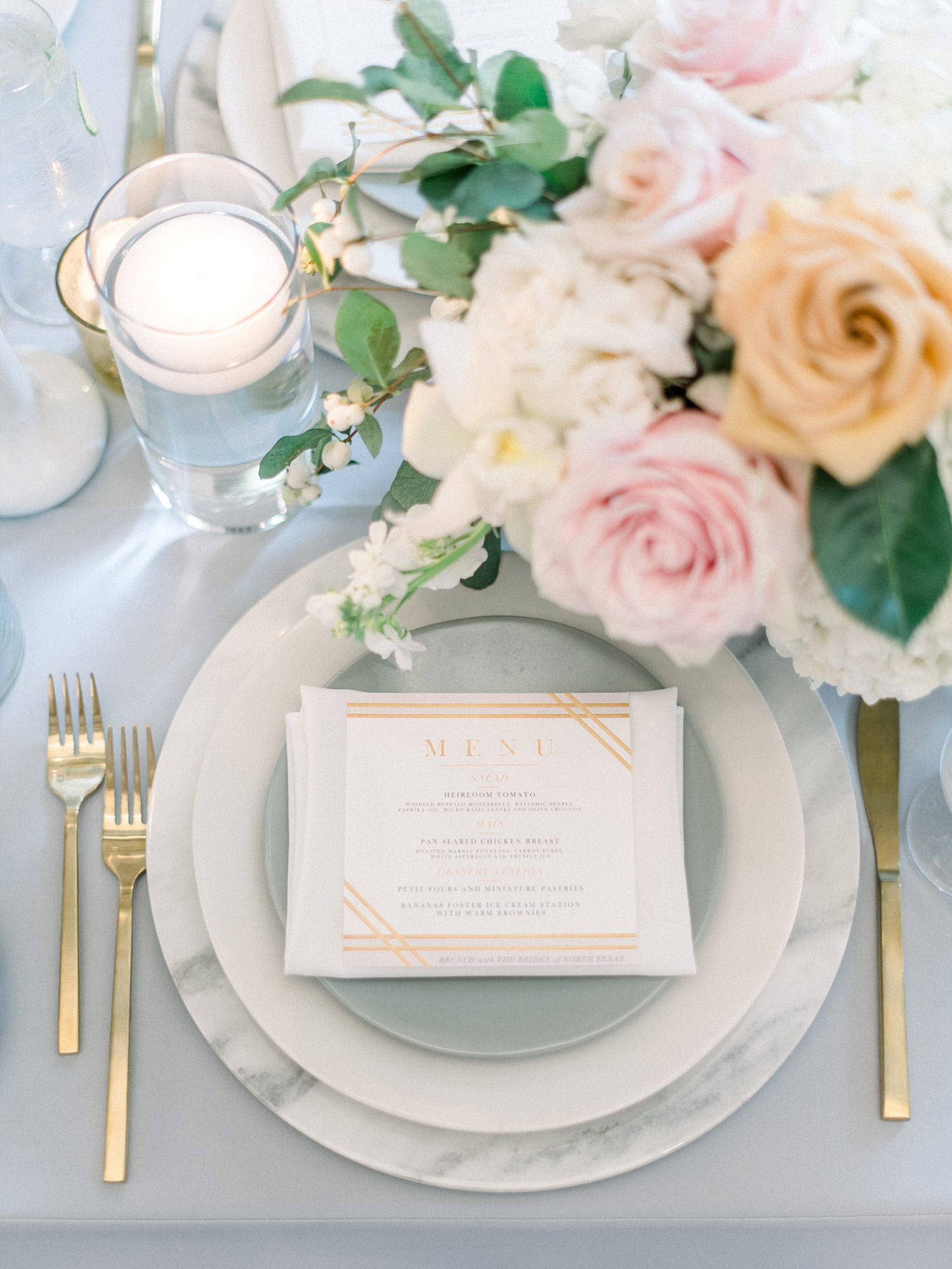 Place setting with marble charger and gold silverware