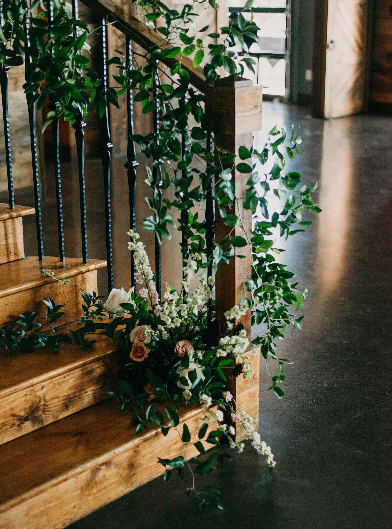 Greenery and flower install at the base of wood stairs