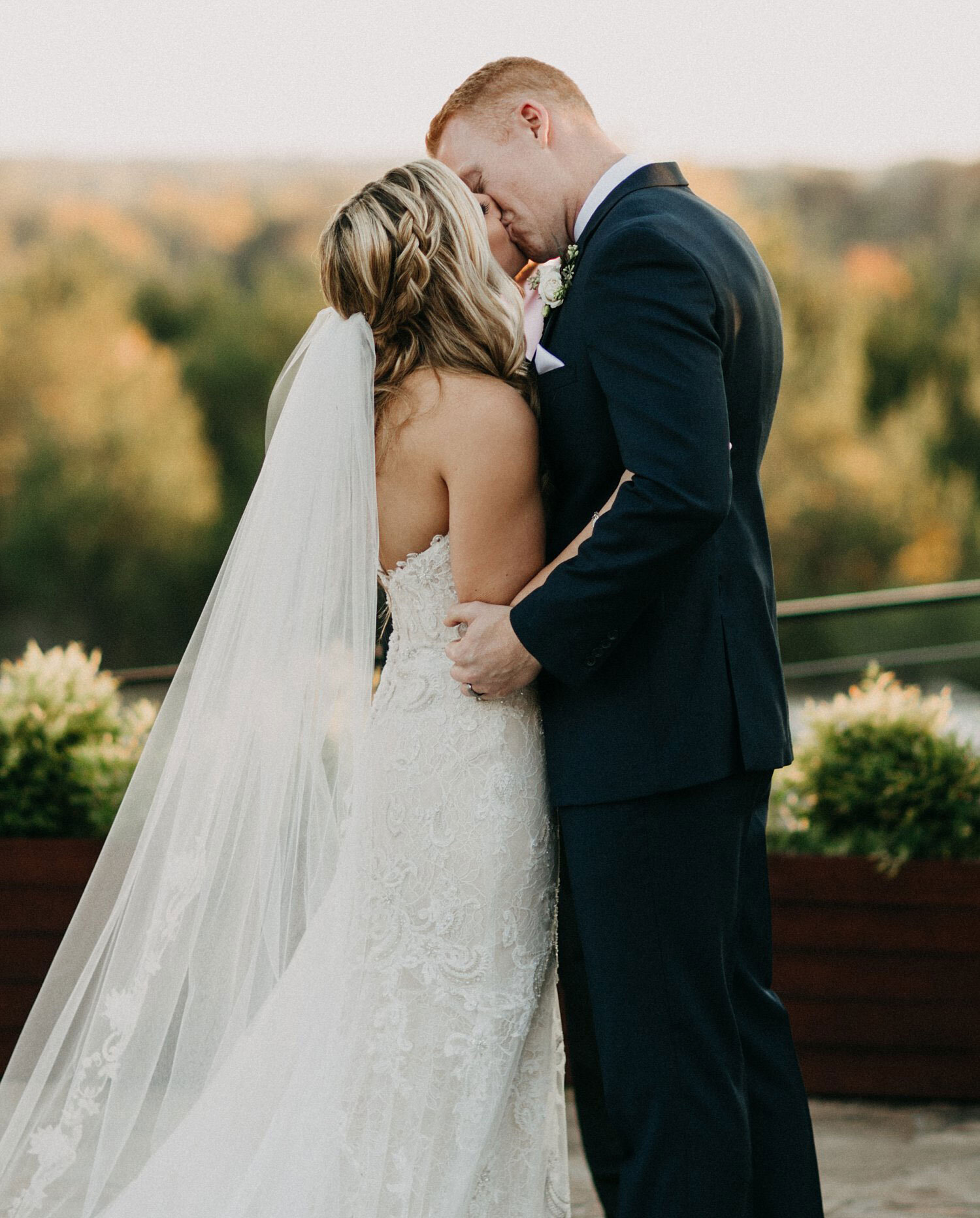 Bride &amp; groom kissing with hills in the background