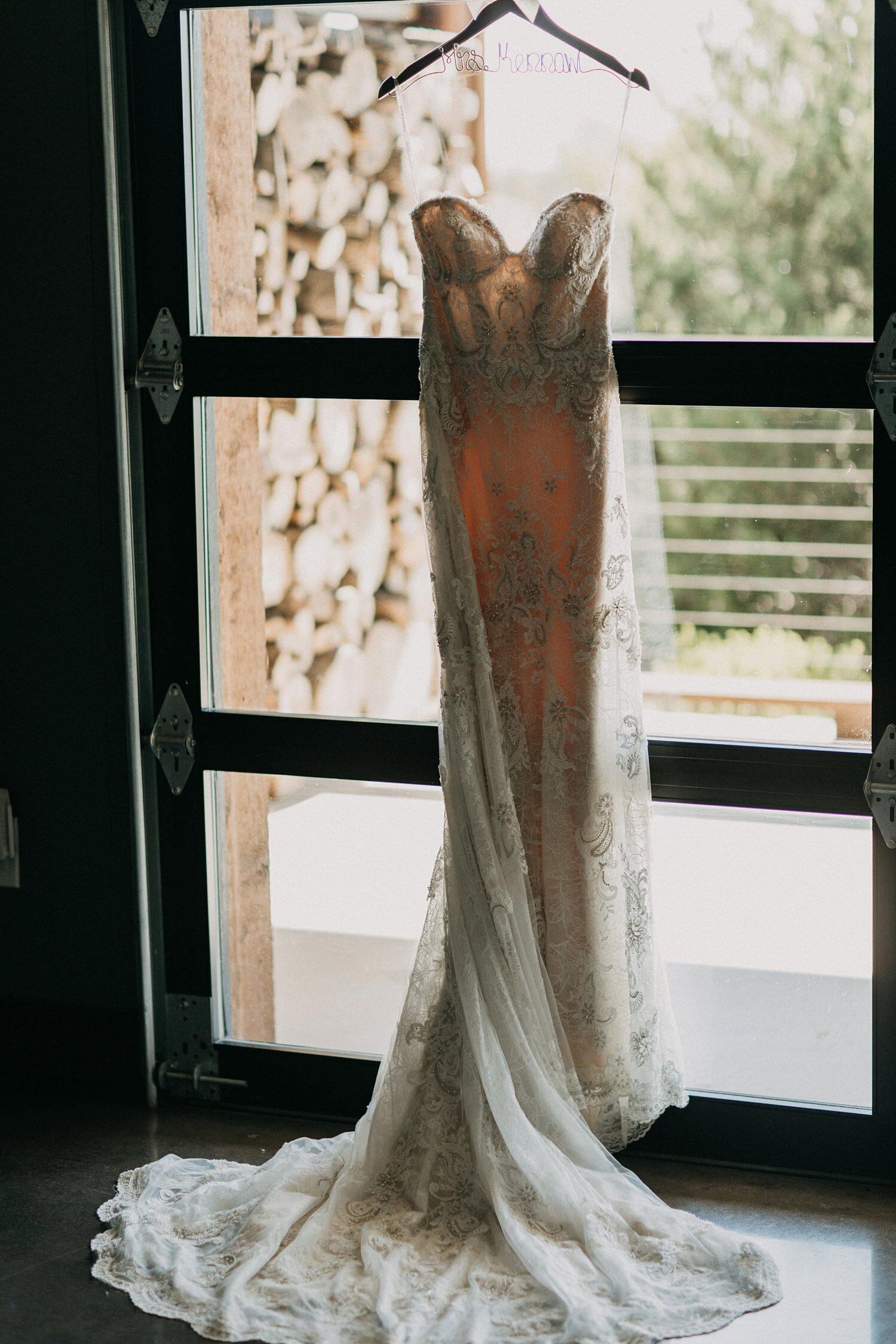 Wedding dress hanging on black framed window