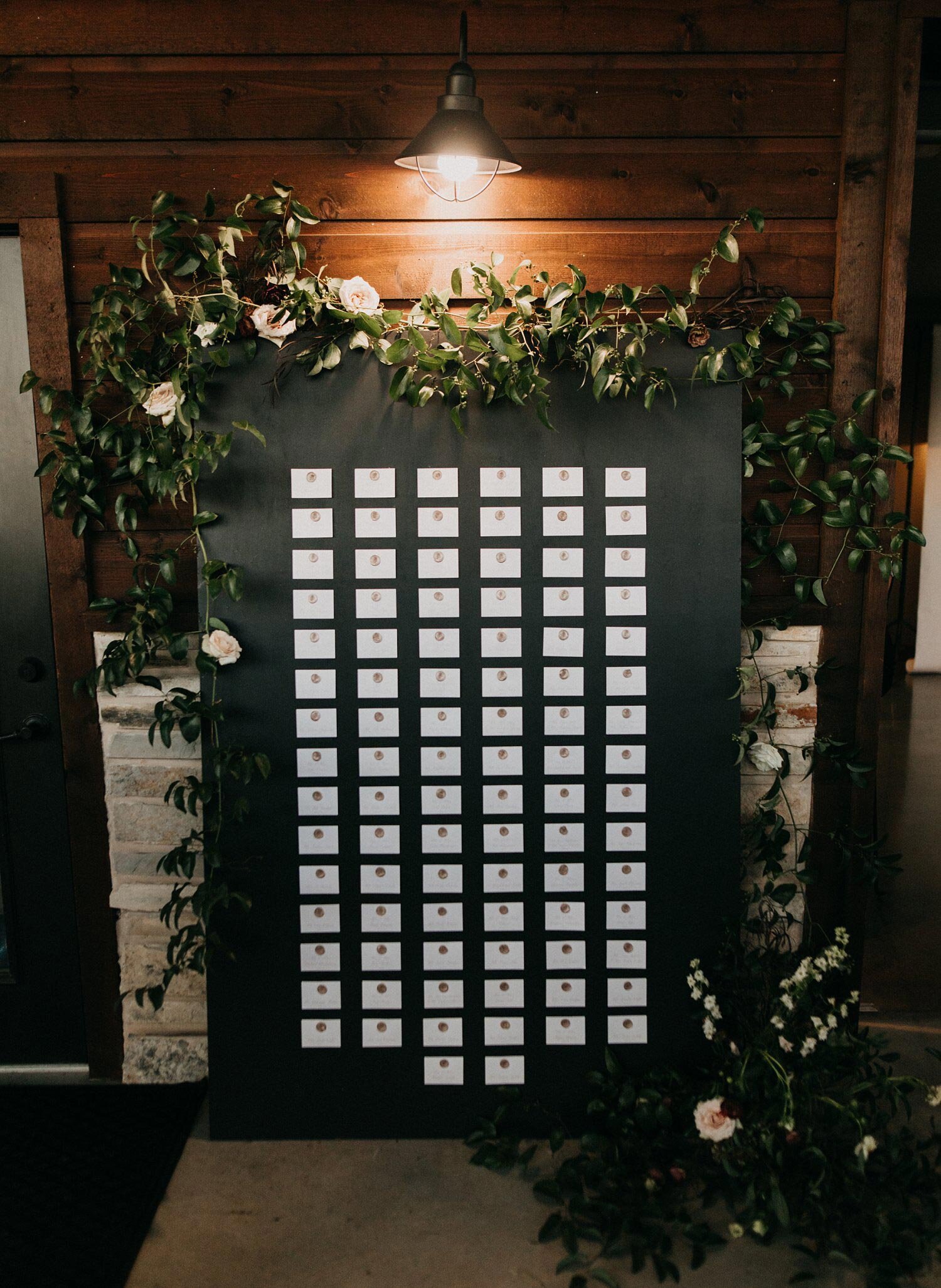 Black seating chart with white escort cards