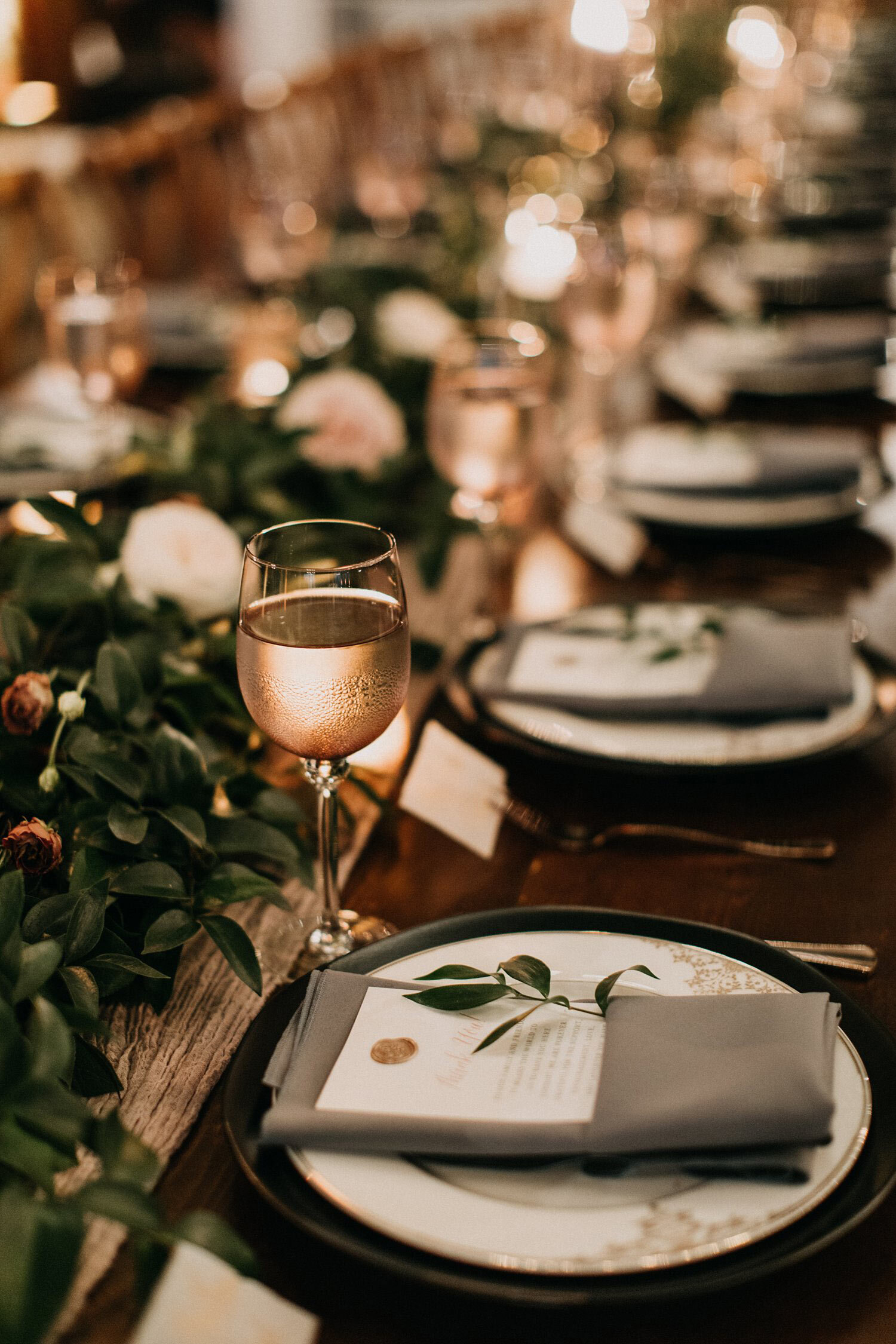 Black charger, copper dinner plate, wax seal menu &amp; grey napkin