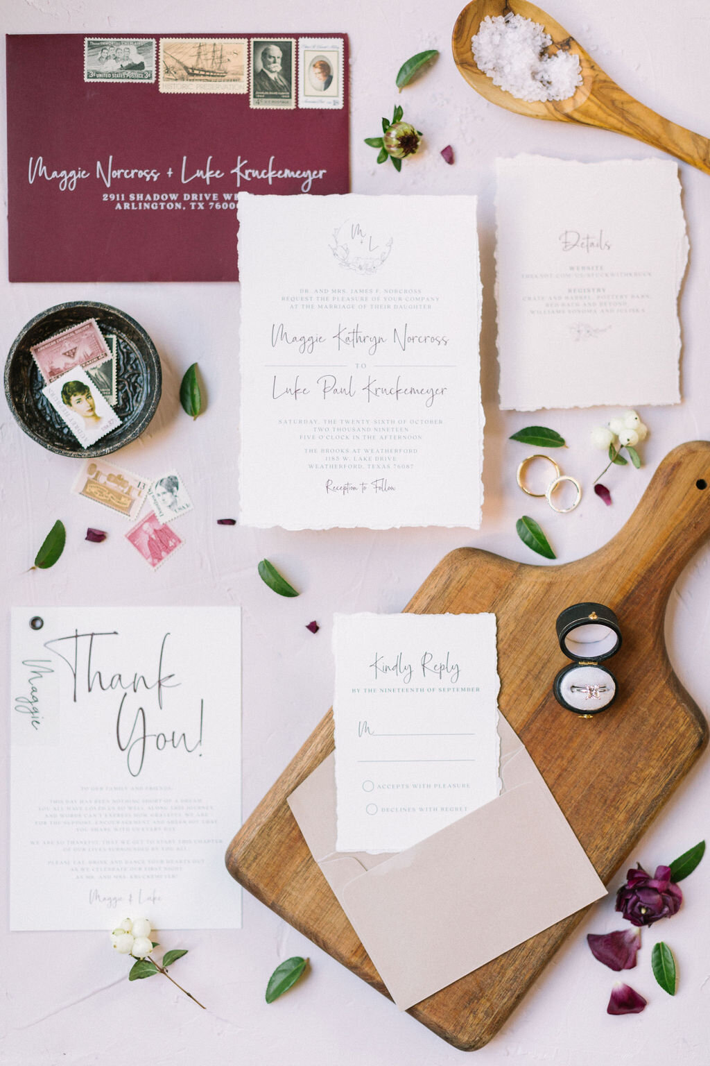 Burgundy and blush wedding invitation on a cutting tray