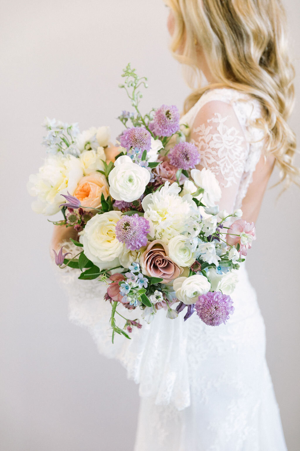 Purple peach white and blue bridal bouquet of flowers