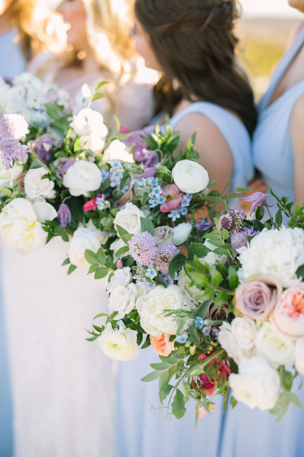 Bridesmaids with blue dresses &amp; purple flower bouquets