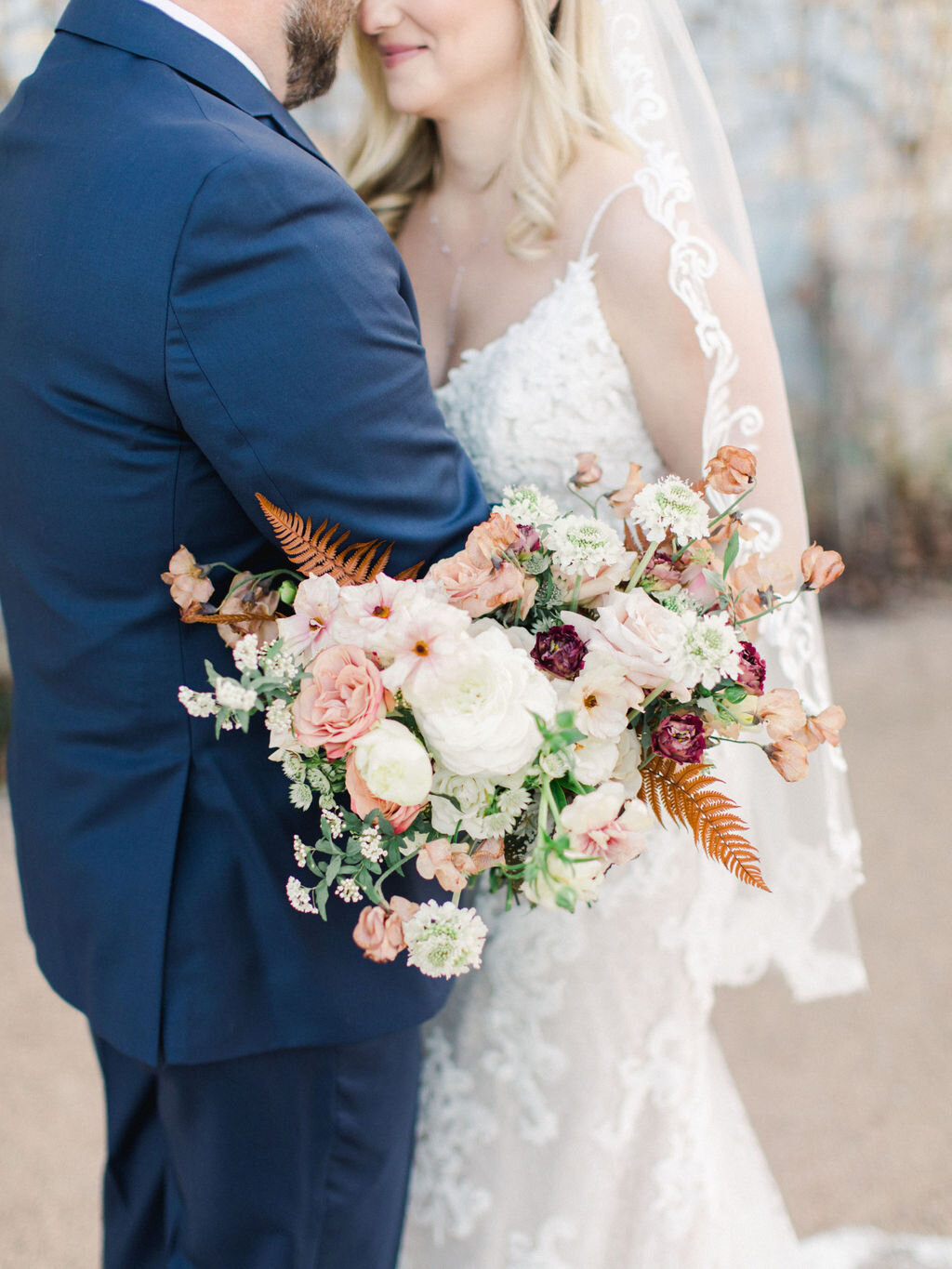 Fort Worth Bride holding a orange, red, pink and white wedding flower bouquet