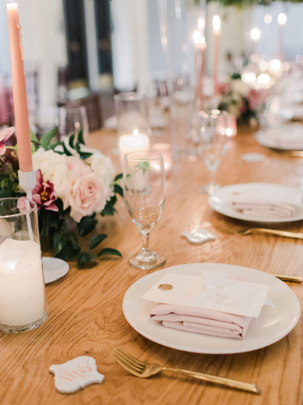 Pink napkins, wax seal menus, and a farm table