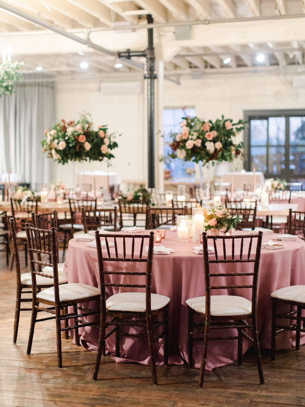Wedding reception with mauve linens and wood farm tables at Brik Venue